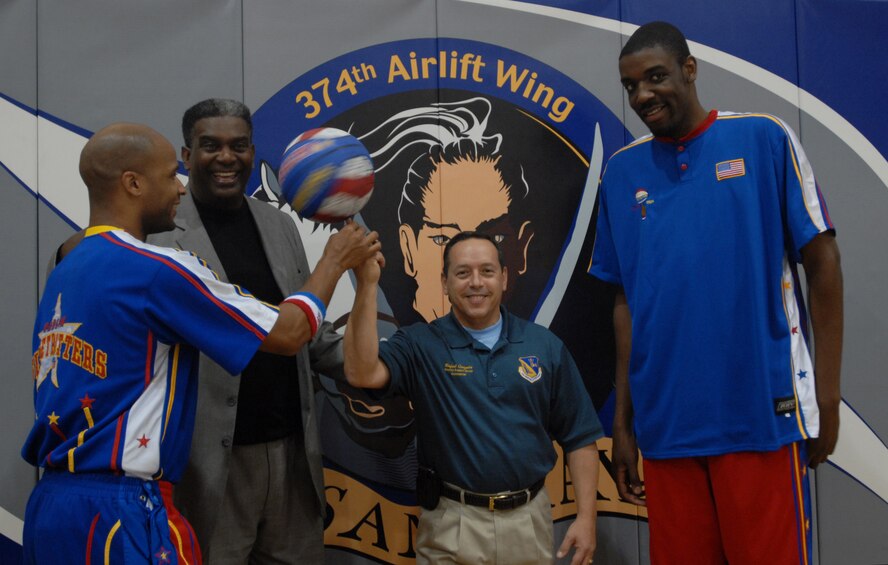 YOKOTA AIR BASE, Japan-Members of the Harlem Globetrotters present Col. Rafael Quezada, commander of the 374th Mission Support Group, with a basketball signed by the whole team Dec. 5 at the Samurai Fitness Center at Yokota Air Base. The Globetrotters were on a tour that included stops at all of the bases in the Pacific region. (U.S. Air Force photo by Airman Sean Martin)