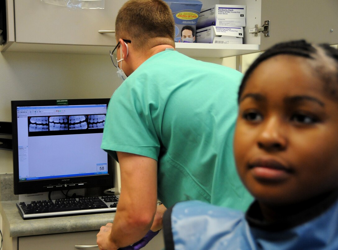 ANDERSEN AIR FORCE BASE, Guam - Capt. Benjamin Hall, 36th Medical Group officer in charge of Dental Radiology, reviews digital images of Airman 1st Class Keesha Harris's teeth here Dec. 5. Andersen's Dental Clinic quadrupled their capability in terms of time and efficiency by going digital rather than sticking with film. (U.S. Air Force photo by Airman 1st Class Courtney Witt)
