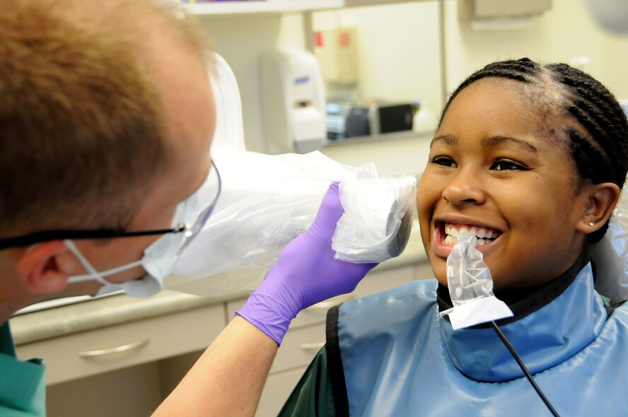 ANDERSEN AIR FORCE BASE, Guam - Capt. Benjamin Hall, 36th Medical Group officer in charge of Dental Radiology, aligns the X-Ray machine with the sensor that is placed in Airman 1st Class Keesha Harris's mouth here Dec. 5. Radiation exposure drops 80 percent by using digital radiology over film. (U.S. Air Force photo by Airman 1st Class Courtney Witt)
