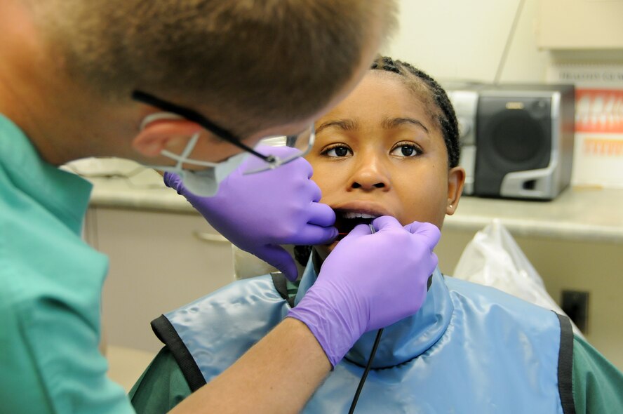 ANDERSEN AIR FORCE BASE, Guam - Capt. Benjamin Hall, 36th Medical Group officer in charge of Dental Radiology, places a sensor, also known as a Charged Coupled Device or CCD along the side of Airman 1st Class Keesha Harris's gum line here Dec. 5. A cable that is attached to the sensory at one end and a computer on the other, displayed the image onto the screen almost instantaneously. (U.S. Air Force photo by Airman 1st Class Courtney Witt)