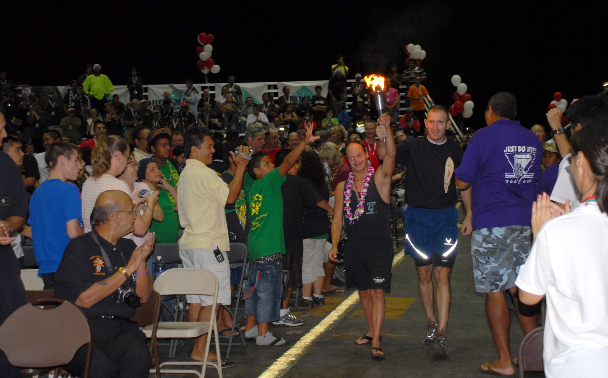 Chris Leone, a Special Olympics Hawaii athlete from Maui, and Lt. Col. Raymund Tembreull, 15th Security Forces commander, lead the way with the torch run kicking off the Special Olympics Holiday Classic games. (U.S. Air Force Photo/Staff Sgt. Erin Smith)