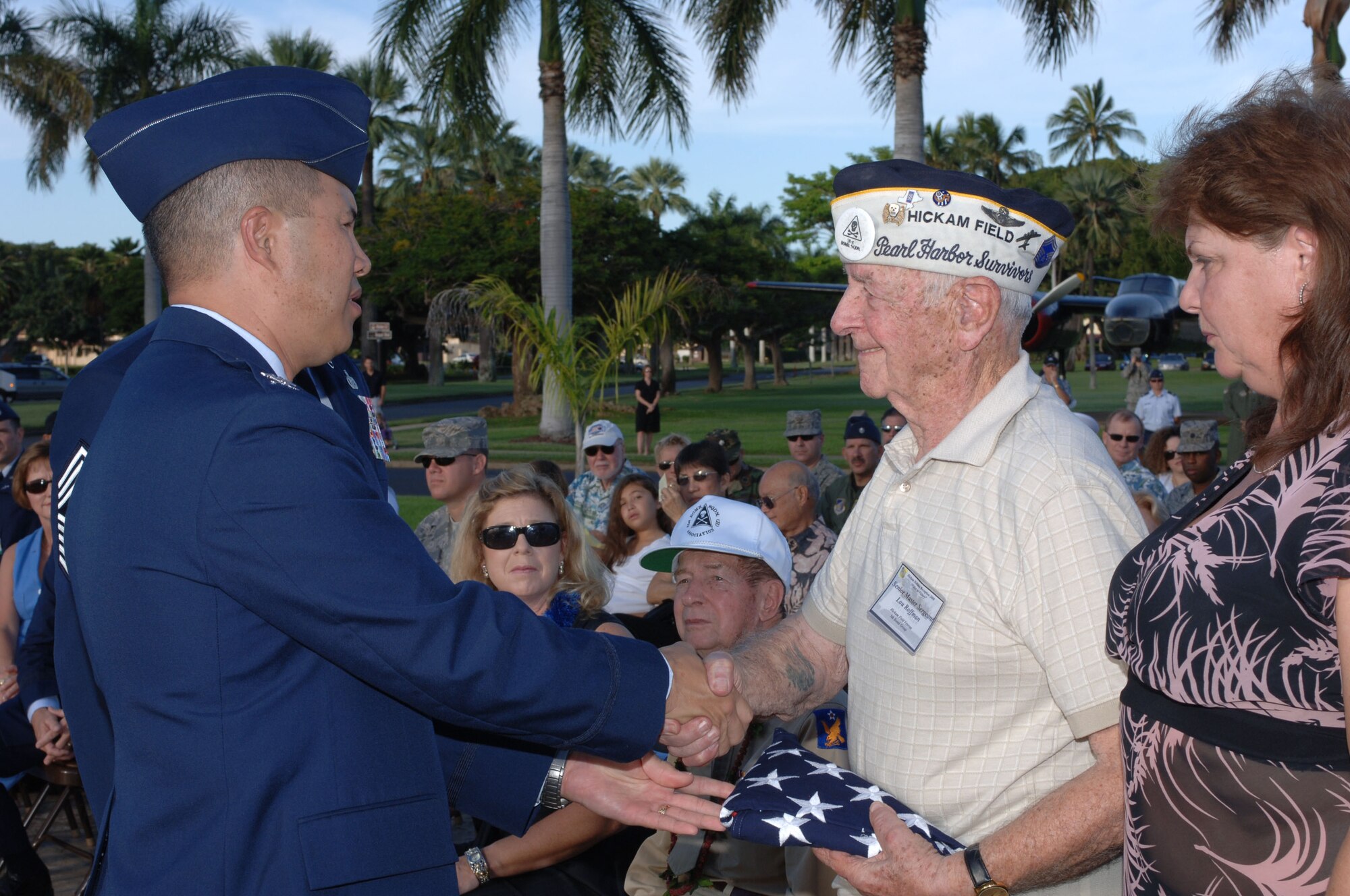 (Dec. 7, 2008) Air Force retired Senior Master Sergeant, and Dec. 7, 1941 Hickam Field Survivor, Lou Roffman shakes hands with the 15th Airlift Wing Commander, Col. Giovanni Tuck, after being presented a folded flag during Sunday's Hickam Field remembrance ceremony.  Roffman was accompanied by his daughter, Sally Lareau (right).  (U.S. Air Force Photo/Oscar A. Hernandez)  

