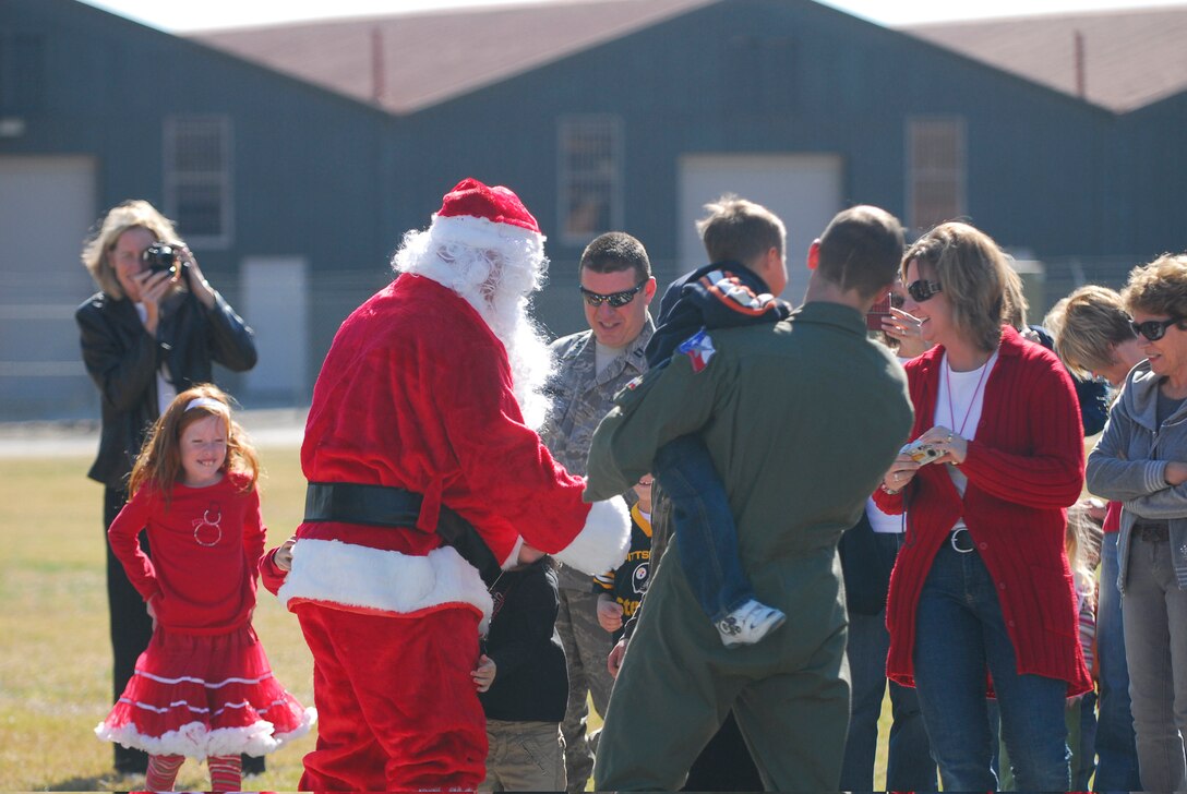 The 149th Fighter Wing greets Santa Claus as he arrives on Lackland Air Force Base, Texas, Dec. 7, 2008. After "fllying in" on an F-16 Fighting Falcon, he greeted wing members and their families and took a moment out of his busy schedule to pose for pictures with many of the members' children.