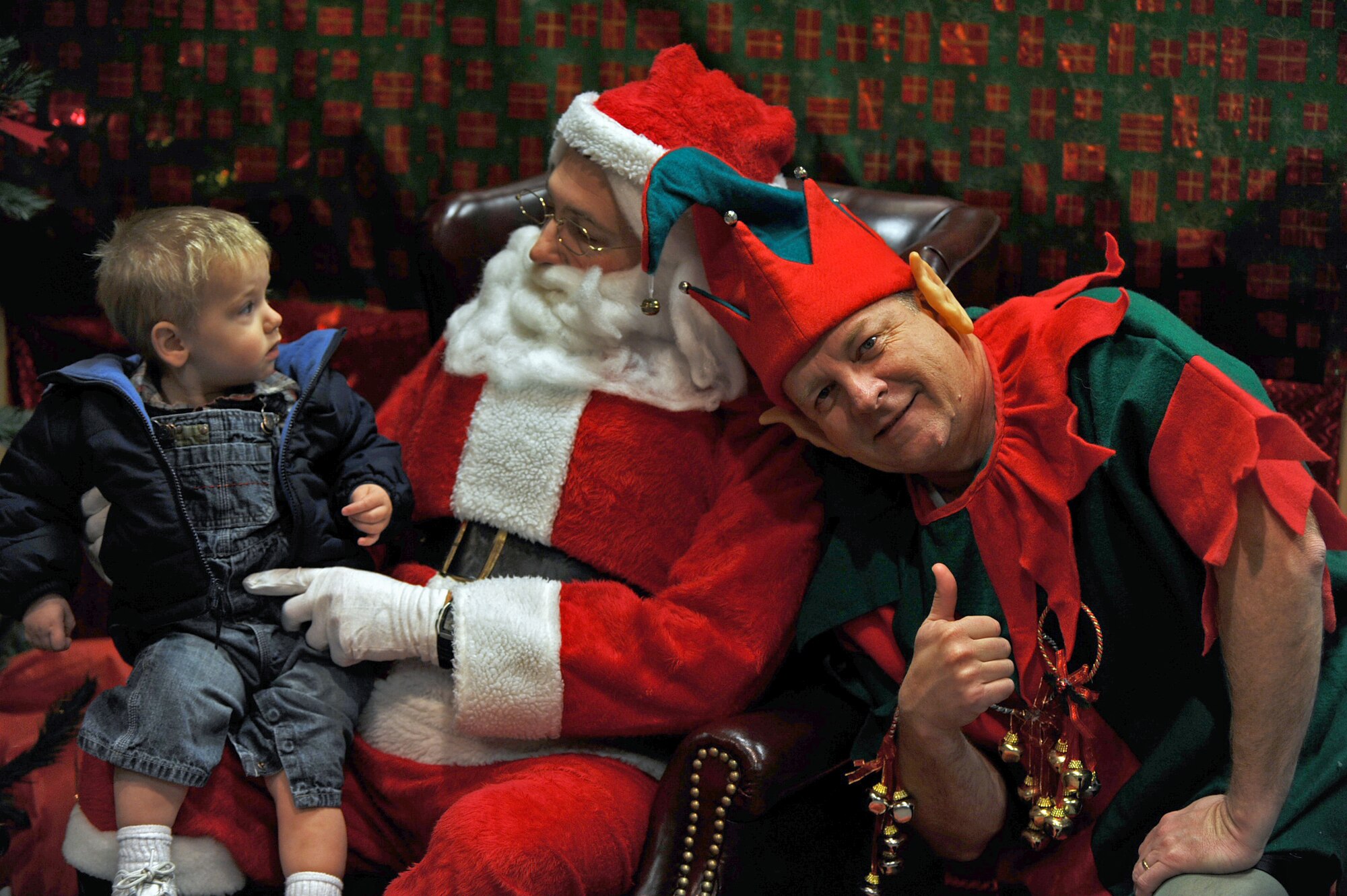 Tanner Heincker, 1, visits with Santa Claus during the 931st Air Refueling Group's annual children's Christmas party. Col. Edsel A. "Archie" Frye Jr., 931st commander, served as one of Santa's elfs during the party. Lt. Col. Sam Schofield, 931st inspector general, filled in as Santa. Tanner is the grandson of Senior Master Sgt. Mack Housman, 931st Military Personnel Flight superintendent. (U.S. Air Force photo/Tech. Sgt. Jason Schaap)