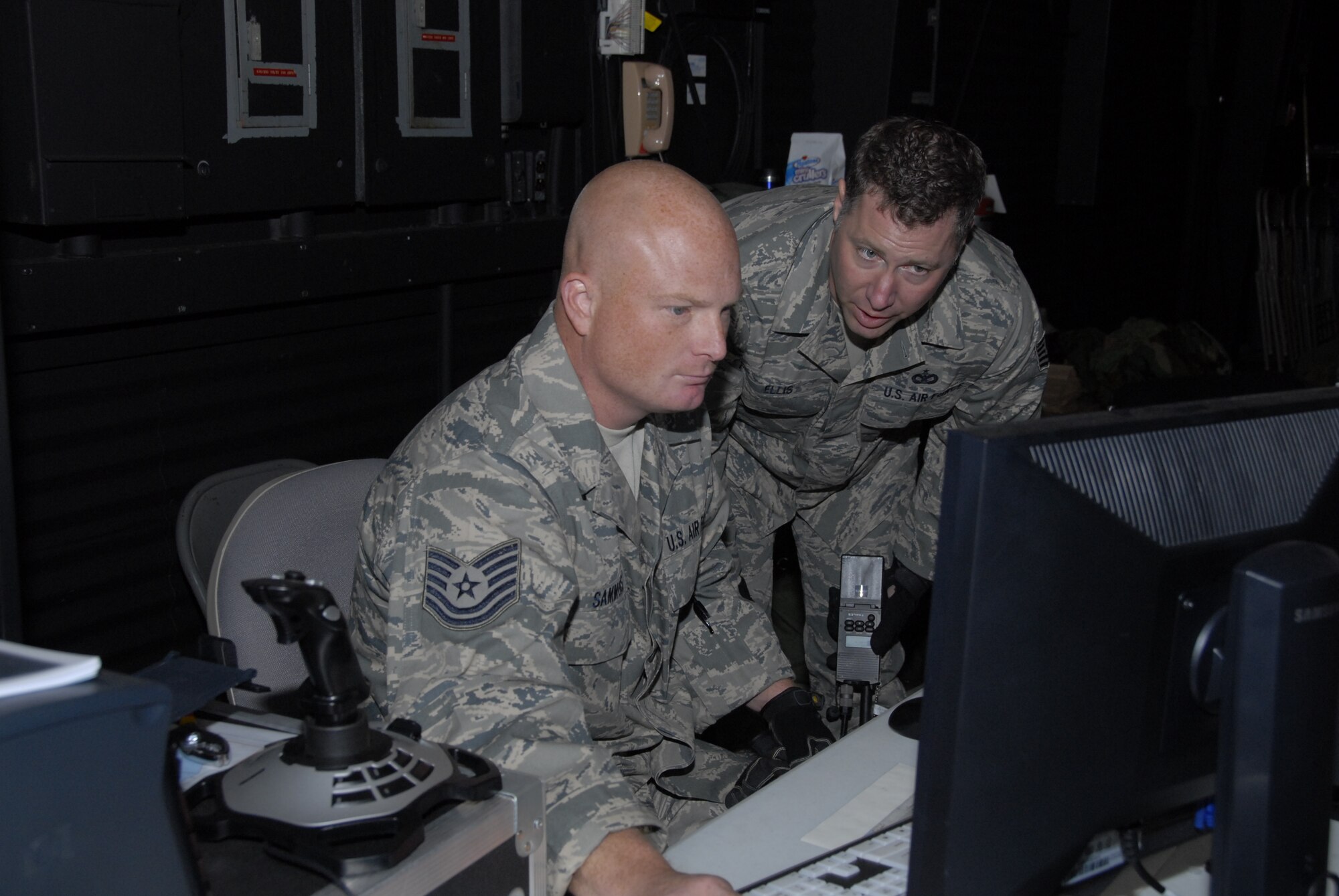 Tech Sgts. Jody Sammons and Jay Ellis manage the computer
generated scenarios based on their real-world convoy
experiences in Iraq. (U.S. Air Force photo by Master Sgt. Dan
Richardson.)