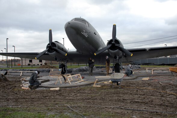 NIAGARA FALLS AIR RESERVE STATION, N.Y. -- Contract workers perform construction work around static display aircraft here. A cement curb and pad is being poured to protect the aircraft.  The curbs will be completed this year and the pads will be poured weather permitting.  The curbs after being poured are covered with heating blankets until the cement cures.  The aircraft are on loan from the National Museum United States Air Force. It is the base's responsibility to maintain display aircraft and to report on their condition annually.  (U.S. Air Force photo by Staff Sgt. Joseph McKee)