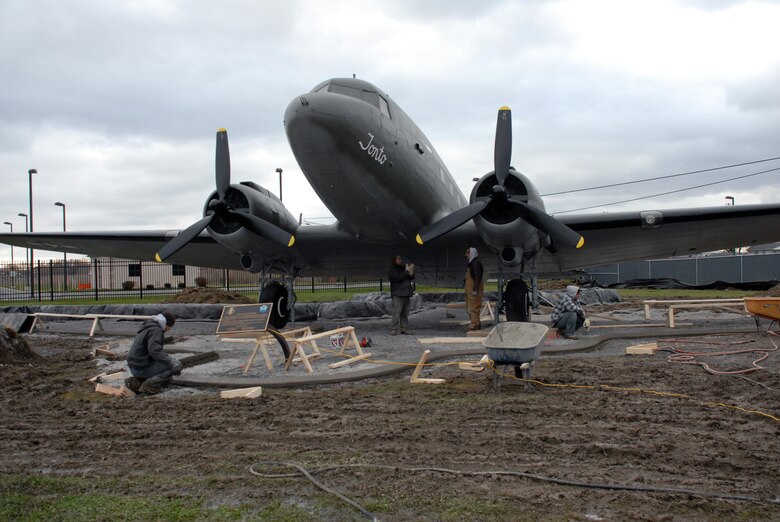 NIAGARA FALLS AIR RESERVE STATION, N.Y. -- Contract workers perform construction work around static display aircraft here. A cement curb and pad is being poured to protect the aircraft.  The curbs will be completed this year and the pads will be poured weather permitting.  The curbs after being poured are covered with heating blankets until the cement cures.  The aircraft are on loan from the National Museum United States Air Force. It is the base's responsibility to maintain display aircraft and to report on their condition annually.  (U.S. Air Force photo by Staff Sgt. Joseph McKee)