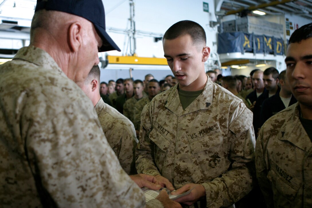USS IWO JIMA, Arabian Gulf (Dec. 8, 2008) – Corporal Terry B. Wyatt receives a miniature American flag and letter from actor and Marine Corps icon R. Lee Ermey aboard USS Iwo Jima, Dec. 8, 2008. Wyatt and nine other 26th Marine Expeditionary Unit Marines received the flags as gifts from the residents of Elnora, Ind., for helping rescue the town from an impending flood in June. Elnora resident Heather Davis, Indiana DJ Diane House and the American Legion sent 150 flags as a token of thanks to the nearly 150 Marines who participated in the mission. Ten flags were forwarded to the ship, currently in the Arabian Gulf for the MEU and Iwo Jima Strike Group's deployment. Ten Marines were hand-picked to represent the subordinate units of the MEU. All Marines receiving flags today directly contributed to the Elnora effort. The remaining 140 flags will be distributed to Elnora mission participants when the MEU returns the Camp Lejeune in early 2009. Ermey is best known for his portrayal of hard-nosed Drill Instructor Gunnery Sgt. Hartman in Full Metal Jacket.  (Official USMC photo by Cpl. Patrick M. Johnson-Campbell) (Released)