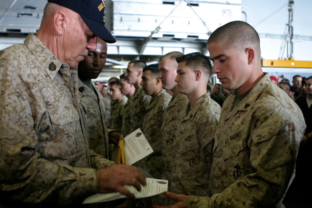 USS IWO JIMA, Arabian Gulf (Dec. 8, 2008) -- Corporal Trevor J. Blackburn receives a miniature American flag and letter from actor and Marine Corps icon R. Lee Ermey aboard USS Iwo Jima, Dec. 8, 2008. Wyatt and nine other 26th Marine Expeditionary Unit Marines received the flags as gifts from the residents of Elnora, Ind., for helping rescue the town from an impending flood in June. Elnora resident Heather Davis, Indiana DJ Diane House and the American Legion sent 150 flags as a token of thanks to the nearly 150 Marines who participated in the mission. Ten flags were forwarded to the ship, currently in the Arabian Gulf for the MEU and Iwo Jima Strike Group's deployment. Ten Marines were hand-picked to represent the subordinate units of the MEU. All Marines receiving flags today directly contributed to the Elnora effort. The remaining 140 flags will be distributed to Elnora mission participants when the MEU returns the Camp Lejeune in early 2009. Ermey is best known for his portrayal of hard-nosed Drill Instructor Gunnery Sgt. Hartman in Full Metal Jacket.  (Official USMC photo by Cpl. Patrick M. Johnson-Campbell) (Released)