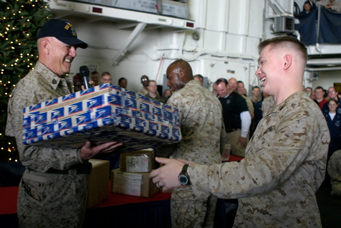 Actor and Marine Corps icon Gunnery Sgt. R. Lee Ermey hands Sgt. Cory W. Hamilton of 26th Marine Expeditionary Unit a package during a mail call aboard the USS Iwo Jima in the Arabian Gulf, Dec. 8, 2008.  Ermey visited the USS Iwo Jima as a Moral, Welfare and Recreation event for deployed troops during the holiday season. The 26th MEU and Iwo Jima Strike Group are currently deployed to the 5th fleet area of operation.