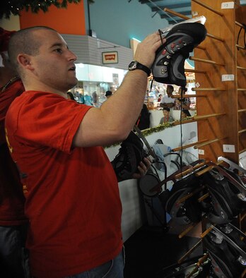 1st Lt. James Carmichael, 23rd Expeditionary Bomber Squadron, Andersen Air Force Base, Guam inspects ice skates on Dec. 6 during a fund raising event for Habitat for Humanity in downtown Guam. Airmen deployed to Andersen are contributing their time off to volunteer for Guam?s first ?ice? skating rink. The rink, which is a part of ?The Magic of Snow and Ice,? is located in the Guam Premier Outlets, and costs 5 dollars per person, with all proceeds going to the Habitat for Humanity.   Lieutenant Carmichael is deployed to Andersen, from Minot AFB, N.D.(U.S. Air Force photo/ Master Sgt. Kevin J. Gruenwald) released
