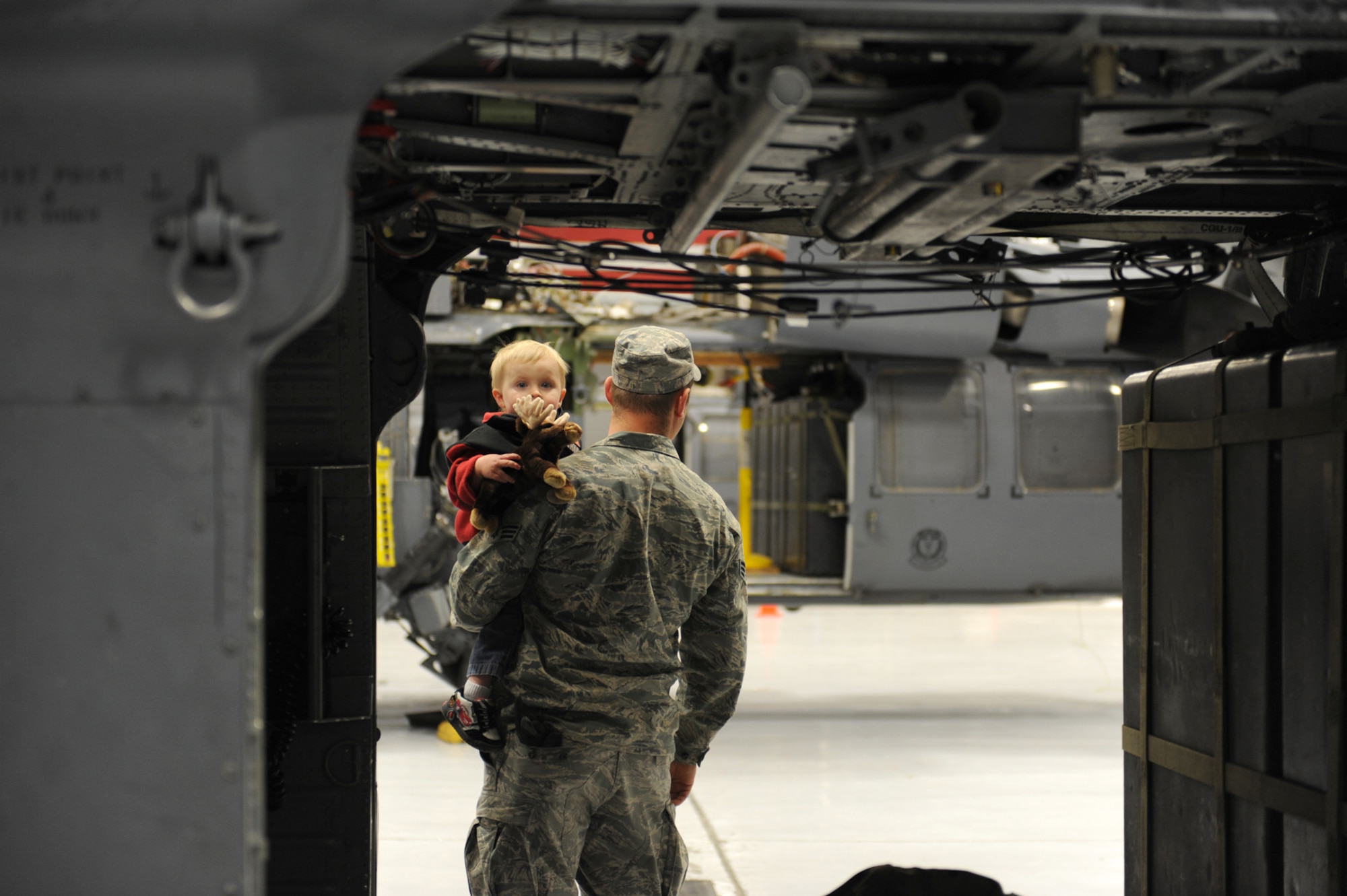 Senior Airman Matthew Ohara, an HH-60 crew chief assigned to the 763rd Maintenance Squadron, holds his son Jacob Ohara, 2, as he peers through the back of an HH-60 at Nellis Air Force Base, Nev., Dec. 6, 2008. The 763rd MXS and 66th Rescue Squadron Airmen, return home after 3 1/2 months in Southwest Asia, supporting the Global War on Terrorism.
(U.S. Air Force Photo/Senior Airman Larry E. Reid Jr.)