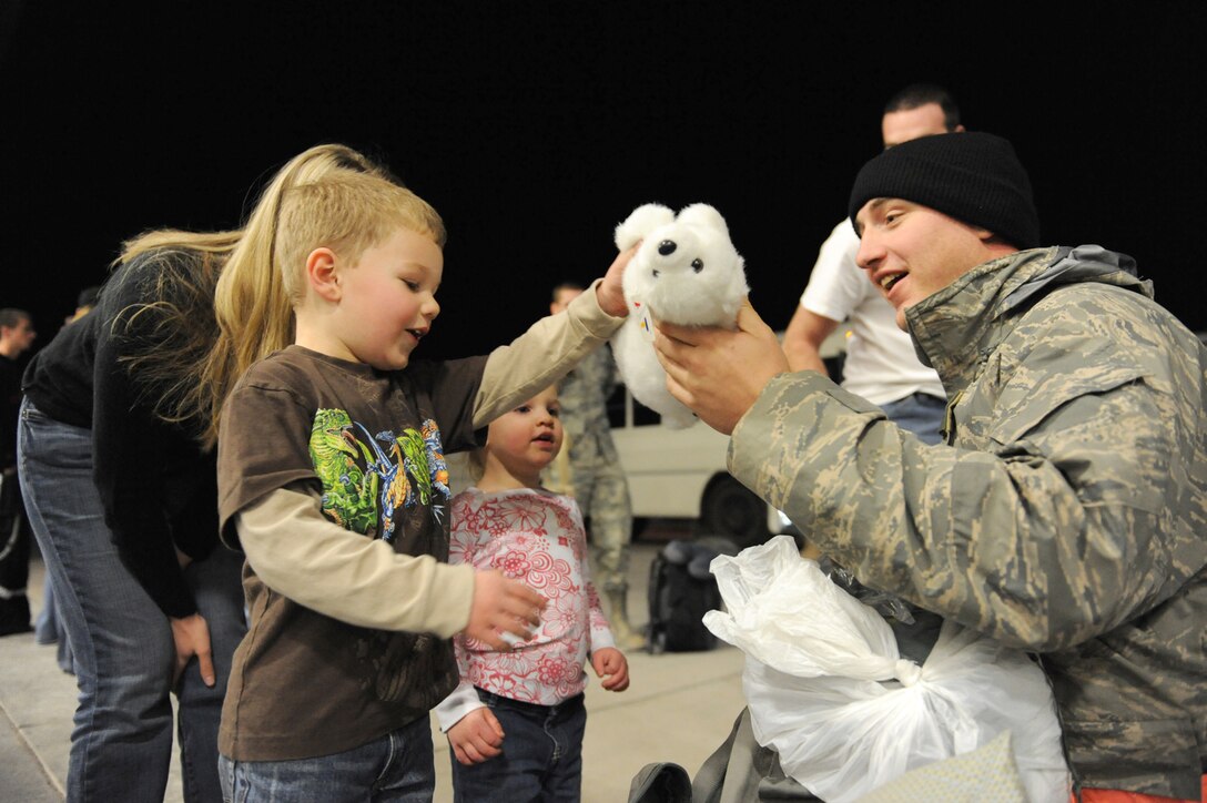 Technical Sgt. Justin Morrison, assistant section chief, propulsions flight, 763rd Maintenance Squadron, presents a gift to his son, four year old Micah Morrison at Nellis Air Force Base, Nev., Dec. 6, 2008. The 763rd MXS and 66th Rescue Squadron Airmen, return home after 3 1/2 months in Southwest Asia, supporting the Global War on Terrorism.
(U.S. Air Force Photo/Senior Airman Larry E. Reid Jr.)