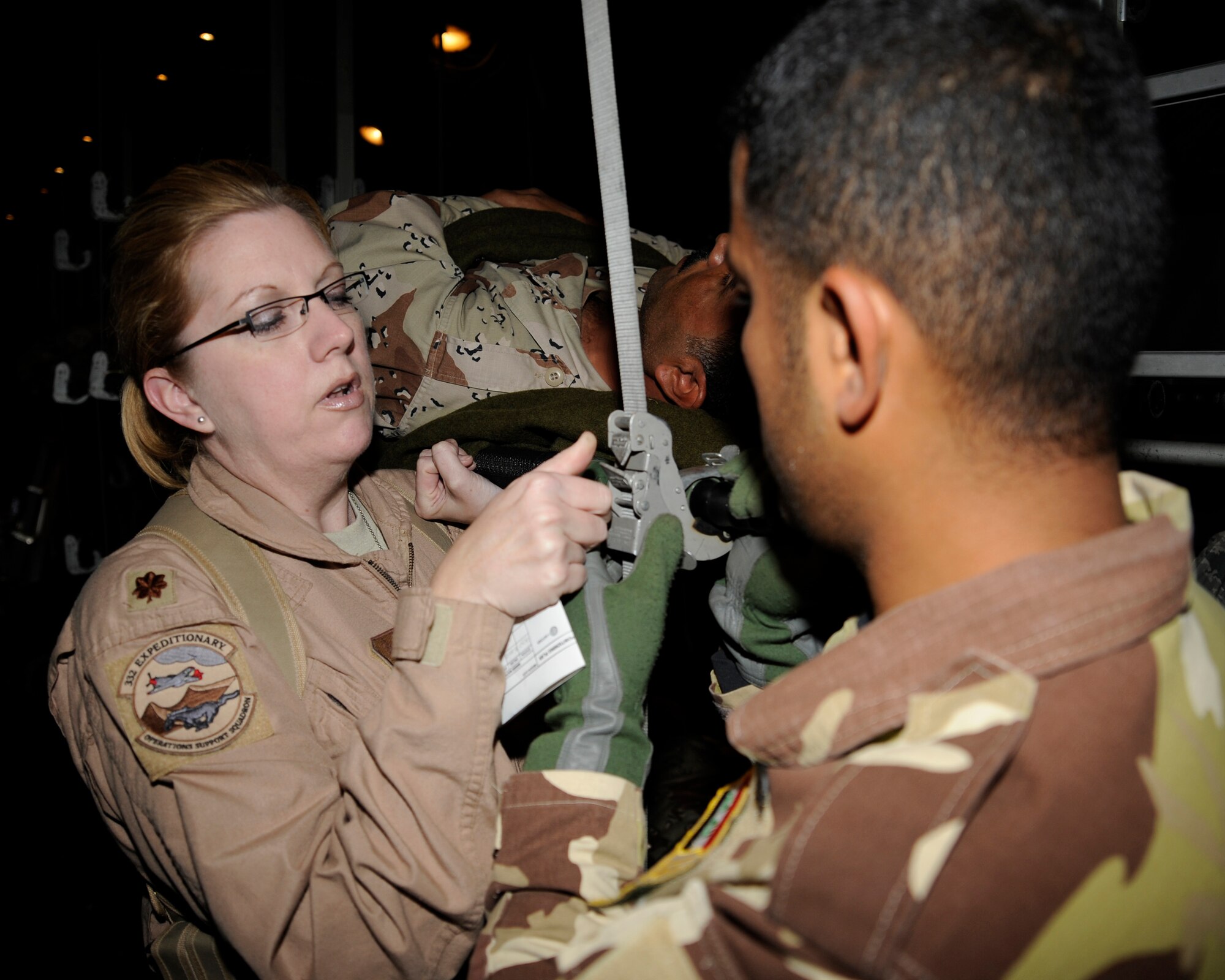 Maj. Bonnie Bosler shows an Iraqi air force medic how to secure a litter for transport in a C-130 Hercules aircraft at New Al-Muthana Air Base, Iraq, Dec. 3. Iraqi airmen attended a 12-day aeromedical evacuation basics course that covered reconfiguring a cargo aircraft into a medical patient aircraft, creating a load plan of patients and coordinating with ground support to load patients. Major Bosler is a flight nurse instructor from the 332nd Expeditionary Aeromedical Evacuation Flight. (U.S. Air Force photo/Staff Sgt. Paul Villanueva II)
