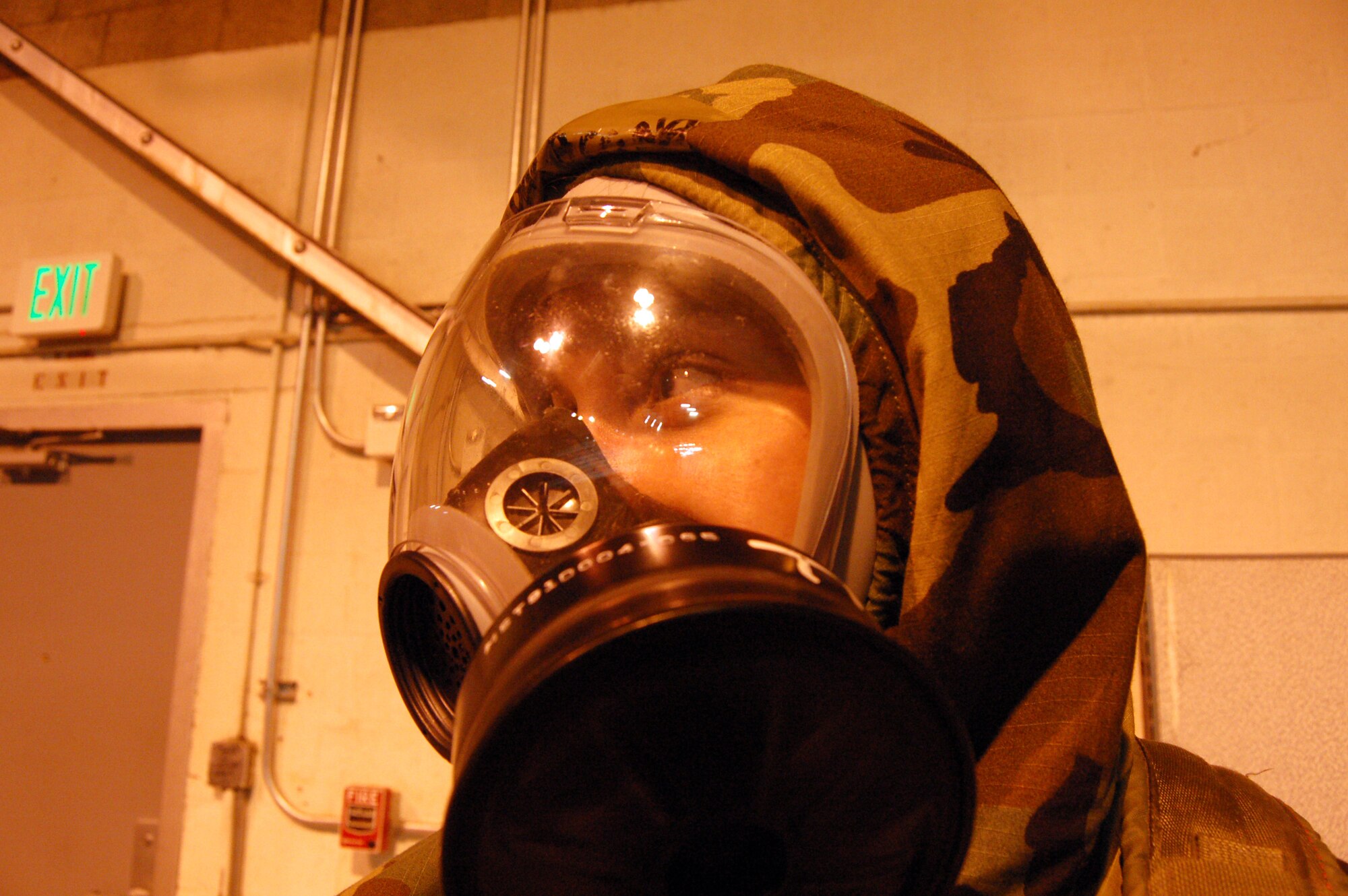 Senior Airman Dana Cona, 95th Security Forces Squadron armorer, dons a gas mask and chemical suit during a Chemical, Biological, Radiological and Nuclear training Dec. 4 at the Mobility Processing Center. The training is part of preparation for the upcoming Unit Compliance Inspection in January. (Air Force photo by Senior Airman Julius Delos Reyes)