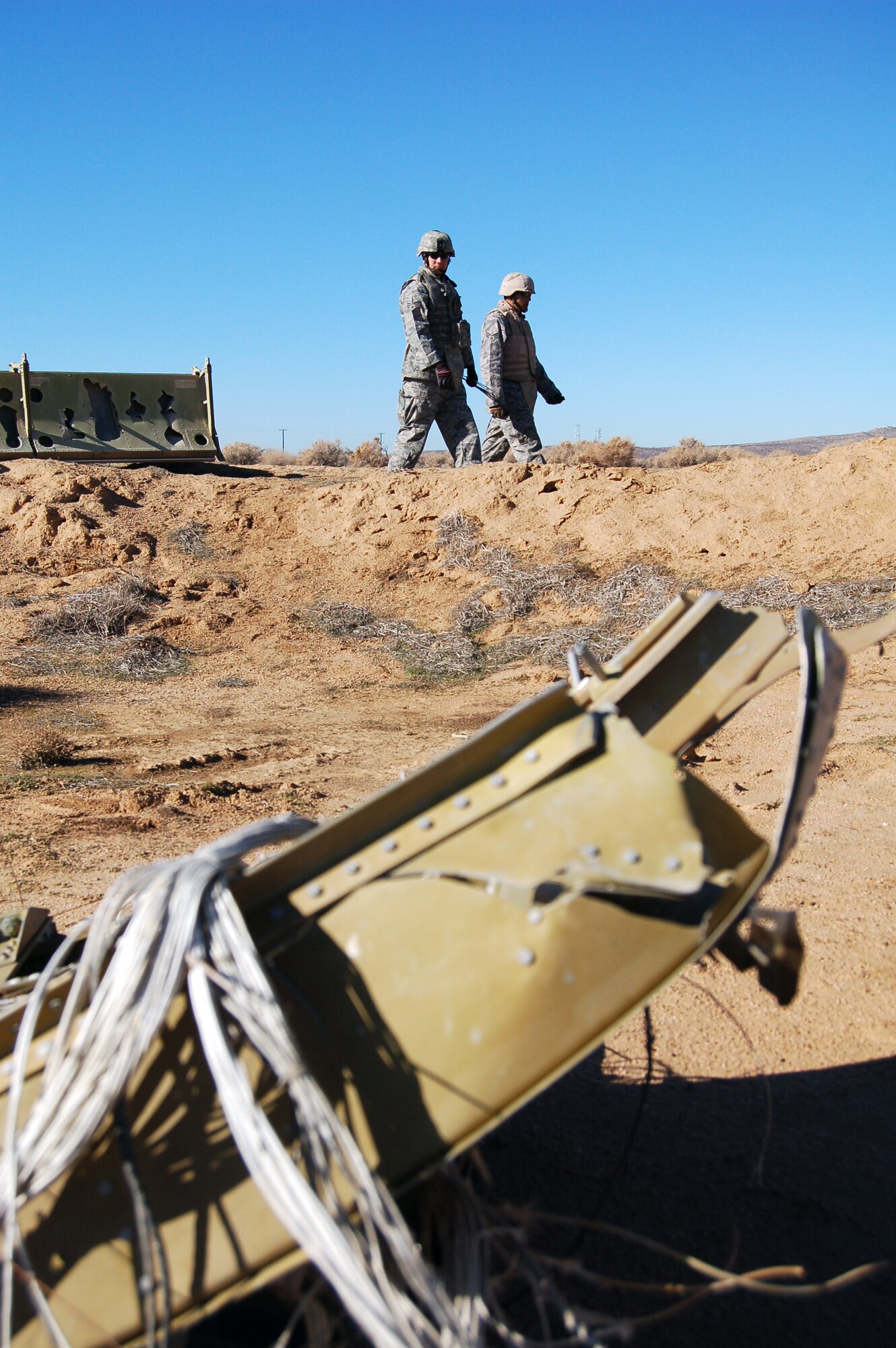 Airmen with the Edwards Explosive Ordnance Disposal Unit perform assessment of an F-16 Fighting Falcon crash site during an Emergency Management Exercise Dec. 3 at Camp Corum. This is in preparation for the upcoming Unit Compliance Inspection in January. (Air Force photo by Senior Airman Julius Delos Reyes)