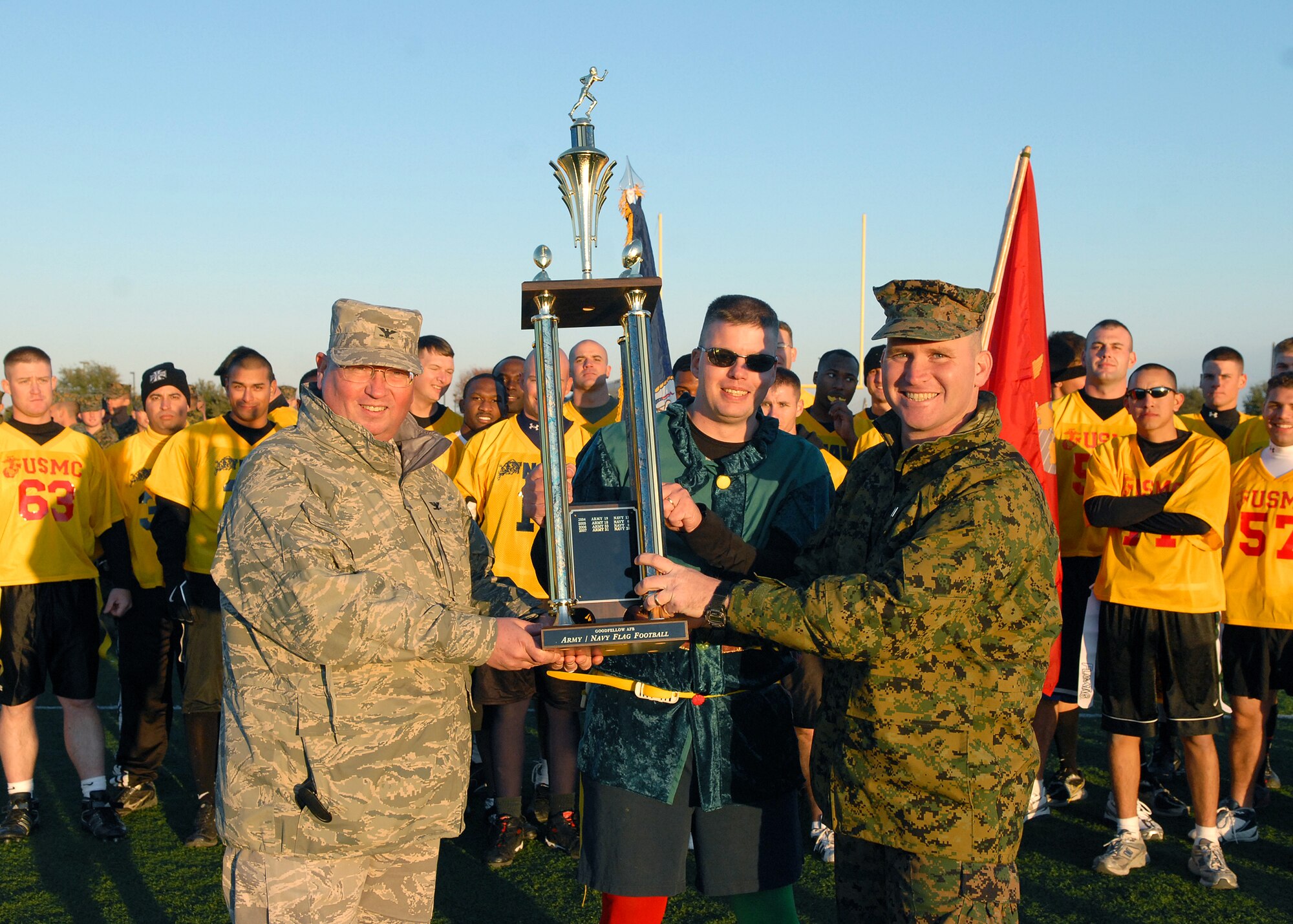 Colonel Richard Ayres (left), 17th Training Wing commander, presents the Army-Navy flag football game trophy to Navy Lt. Lonnie Griffith (center), Center for Information Dominance Detachment officer in charge, and Marine Capt. Henry Billings, Goodfellow Marine Corps Detachment commanding officer, after the annual Army vs. Navy flag football game at Goodfellow Air Force Base on Dec. 5.  Navy defeated Army for the first time in 5 years with a score of 49-47.  (U.S. Air Force photo by Senior Airman Kasabyan Musal).