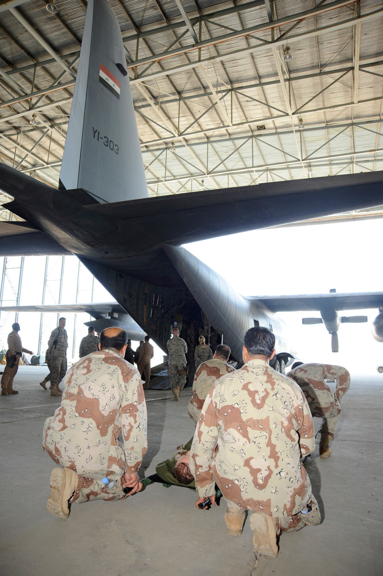 Iraqi air force medics prepare to load a mock patient into a C130 Hercules aircraft for a demonstration for Iraqi senior leadership during their graduation ceremony at New Al-Muthana Air Base, Iraq on Dec. 4, 2008. The Iraqi airmen completed a 12 day aero-medical evacuation basics course that covered reconfiguring a cargo aircraft into a medical patient aircraft, creating a load plan of patients and coordinating with ground support to load patients. (U.S. Air Force photo/Staff Sgt. Paul Villanueva II)