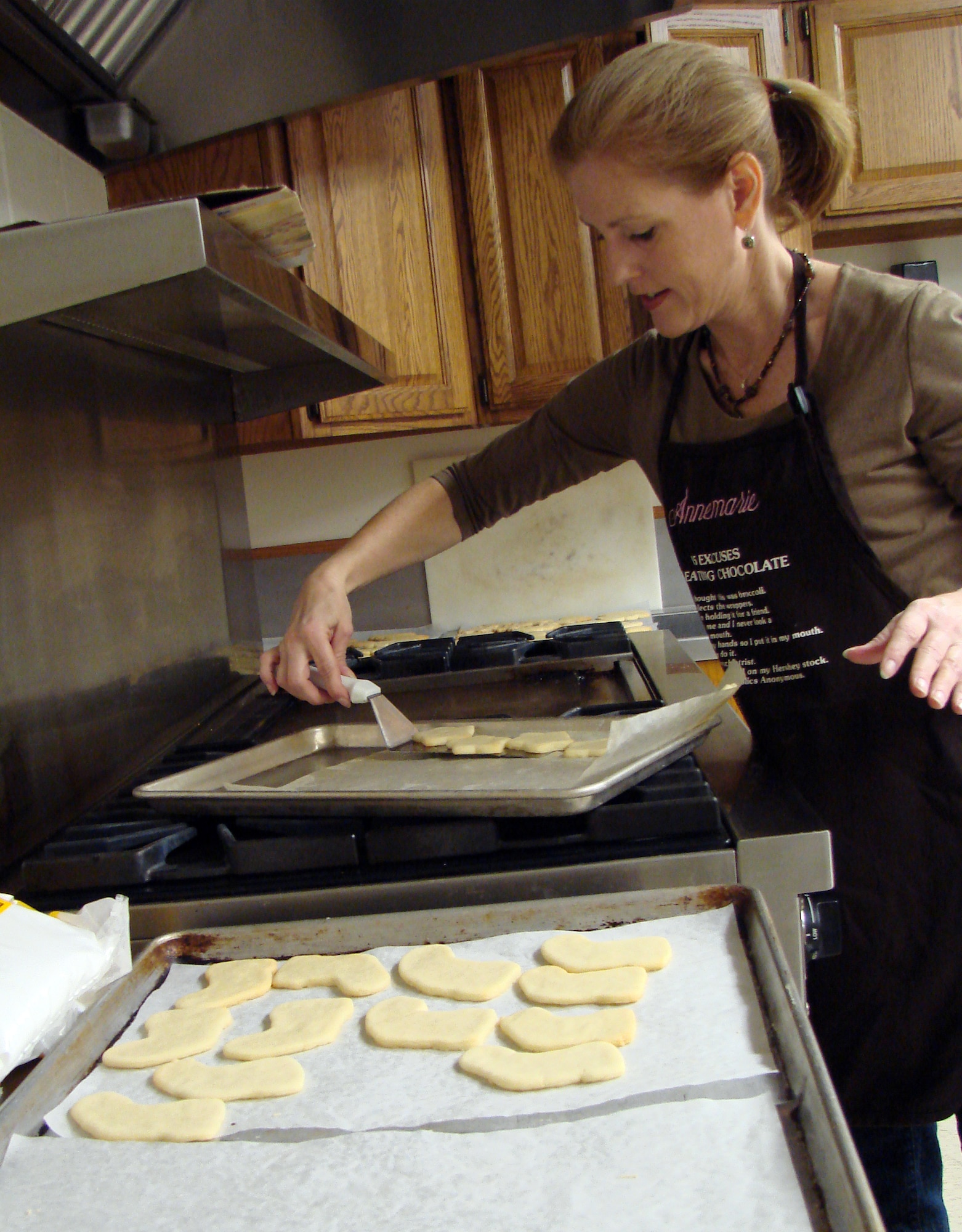 Annemarie Benefield removes some fresh-baked cookies from the oven during the Airman Cookie Drive Friday in the Community Chapel Activities Center at Vance. Members of the Officers’ Spouses and Enlisted Spouses clubs prepared 1,080 cookies for distribution to unaccompanied Airmen in the dormitories Wednesday. Mrs. Benefield is the wife of Lt. Col. Lane Benefield, the 32nd Flying Training Squadron director of operations. (U.S. Air Force photo by Joe B. Wiles)
