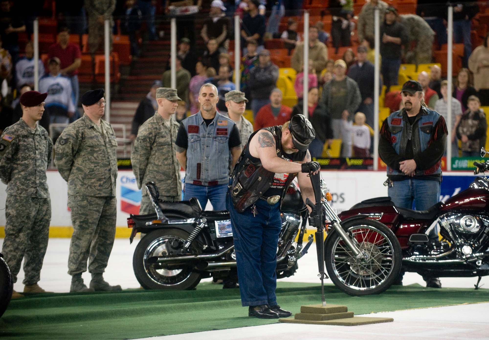 ANCHORAGE, Alaska -- Bull Dog, a member of the Alaska Rolling Thunder, places a rifle on ice as part Prisoner of War ceremony at Aces' military appreciation game Dec. 5. At attendance was Purple Heart recipients Staff Sgt. Larry Franklin and Senior Airman Benjamin Crain from the 3rd Logisitics Readiness Squadron at Elmendorf Air Force Base. (U.S. Air Force photo/Senior Airman Jonathan Steffen)