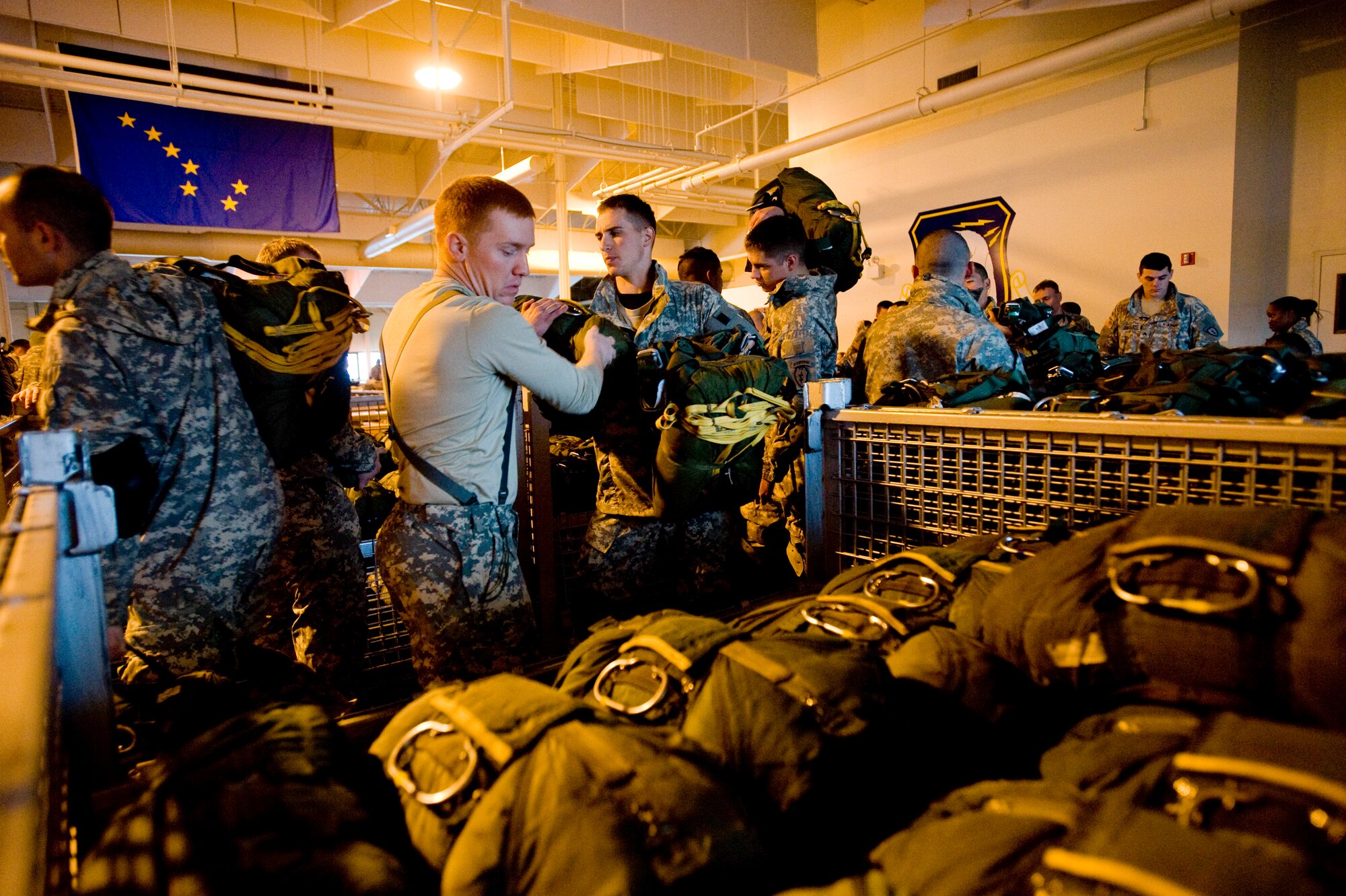 ELMENDORF AIR FORCE BASE -- Army Pfc. Michael Higgiabotham, 4-25 Brigade Special Troops Battalion, passes out emergency parachutes to Soldiers Dec. 5. The 4-25 BTSB uses this time to build up there parachutes prior to getting on the C-17 Globemaster III. (U.S. Air Force photo/Senior Airman Jonathan Steffen)