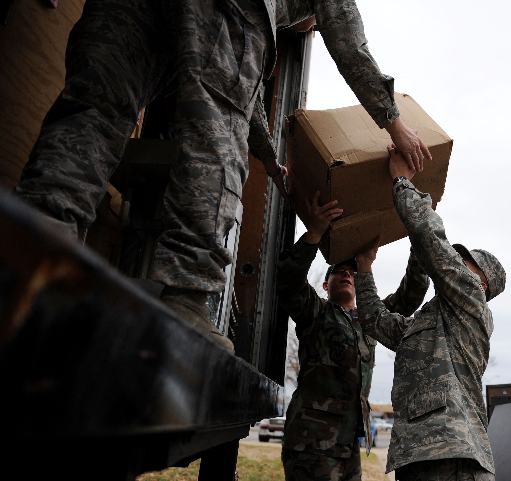 LANGLEY AIR FORCE BASE, Va.-- Airmen from the 83rd Network Operations Squadron lift boxes from the Airmen's Attic into a truck  Dec. 5. Approximately 60 Airmen volunteered on the squadron's Wingman Day to move items to a storage facility allowing the Airmen's Attic to expand.  (U.S. Air Force photo/Airman Rebecca Montez)