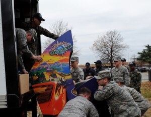 LANGLEY AIR FORCE BASE, Va. -- Airmen from the 83rd Network Operations Squadron work together to lift an arcade game from the Airmen's Attic into a truck Dec. 5. Approximately 60 Airmen volunteered on the squadron's Wingman Day to move items to a storage facility allowing the Airmen's Attic to expand.  (U.S. Air Force photo/Airman Rebecca Montez)