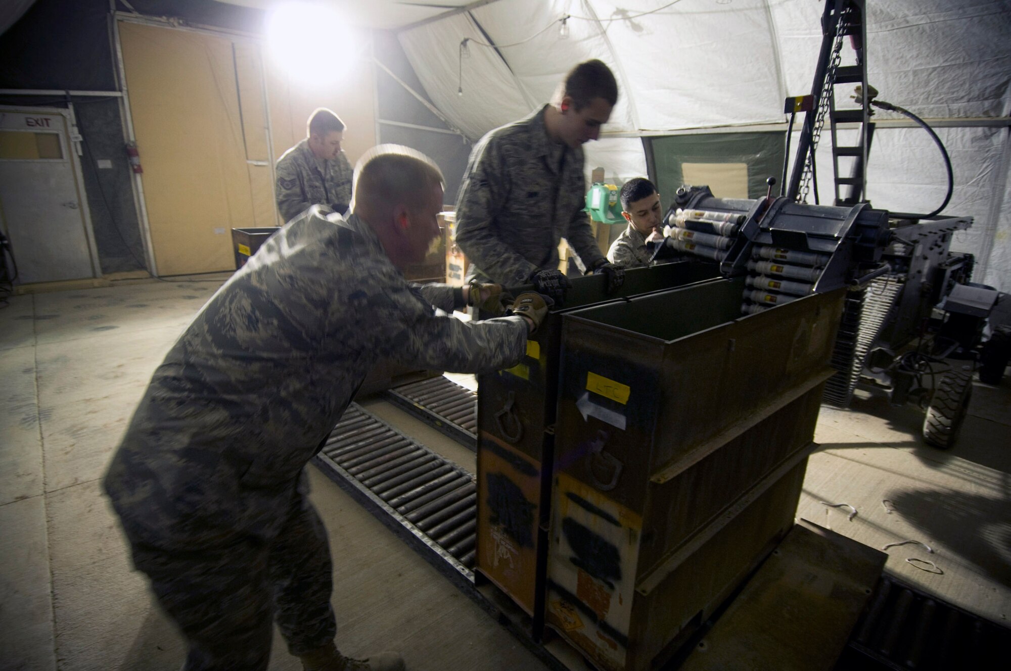 Airmen of the 455th Expeditionary Maintenance Squadron Ammo Flight position an empty container to receive processed rounds from a GFU-7 "Dragon" Dec. 2 at Bagram Airfield, Afghanistan. The team works together to get 30mm rounds ready to be uploaded into an A-10 Thunderbolt II. (U.S. Air Force photo/Staff Sgt. Samuel Morse) 