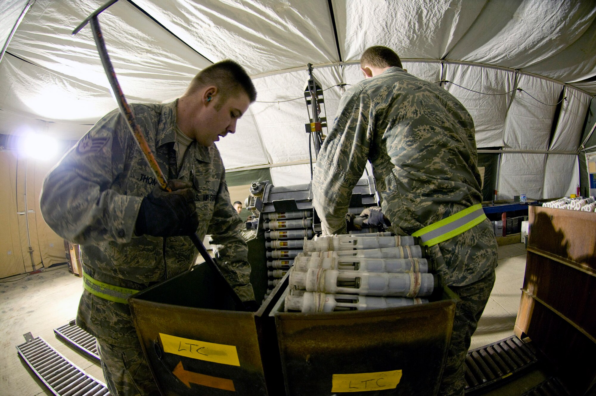 Airman 1st Class Jeb Snow (right) feeds linked tube carriers into a GFU-7 "Dragon" while Staff Sgt. Erik Thomas repacks the processed carriers containing 30mm rounds Dec. 2 at Bagram Airfield, Afghanistan. The two, part of the 455th Expeditionary Maintenance Squadron Ammo Flight, ensure rounds are packed correctly for easy uploading into the A-10 Thunderbolt II. Both are deployed from Mountain Home Air Force Base, Idaho. Airman Snow is from Wasilla, Alaska, and Sergeant Thomas is from Bennington, Vt. (U.S. Air Force photo/Staff Sgt. Samuel Morse)  