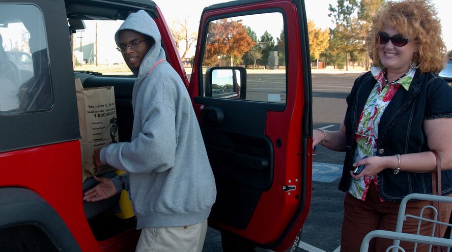 Thorough customer service starts at the entrance of the Altus AFB Commissary and doesn’t stop until customers and their groceries are secure and comfortable in their cars. This high level of service is what prompts Mrs. Holli Hurst to drive from town and through the base security procedures for more than 13 years. Mr. Joseph McCaskill is helping Mrs. Holli load her car after a recent shopping trip.(U.S. Air Force photo/Master Sgt. Paul Dean)

