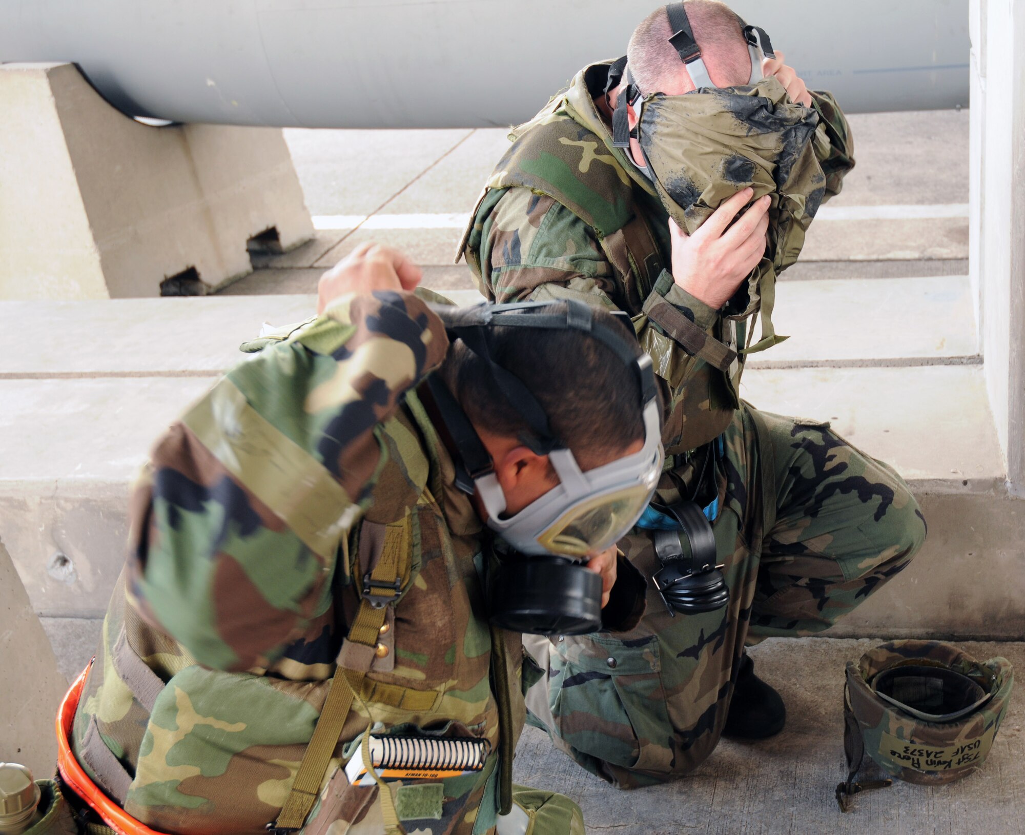 Airman 1st Class Eric McNiel and Tech. Sgt. Kevin Pierce don Mission Oriented Protective Posture 4 gear during a simulated chemical attack Dec. 4 at Kadena Air Base. The simulation is part of Exercise Beverly High 09-01, a joint Air Force-Marine Corps exercise designed to test the ability of both services to execute their critical missions under simulated combat conditions. Airman McNiel and Sergeant Pierce are from the 18th Aircraft Maintenance Squadron. (U.S. Air Force photo/Airman 1st Class Amanda Grabiec) 
