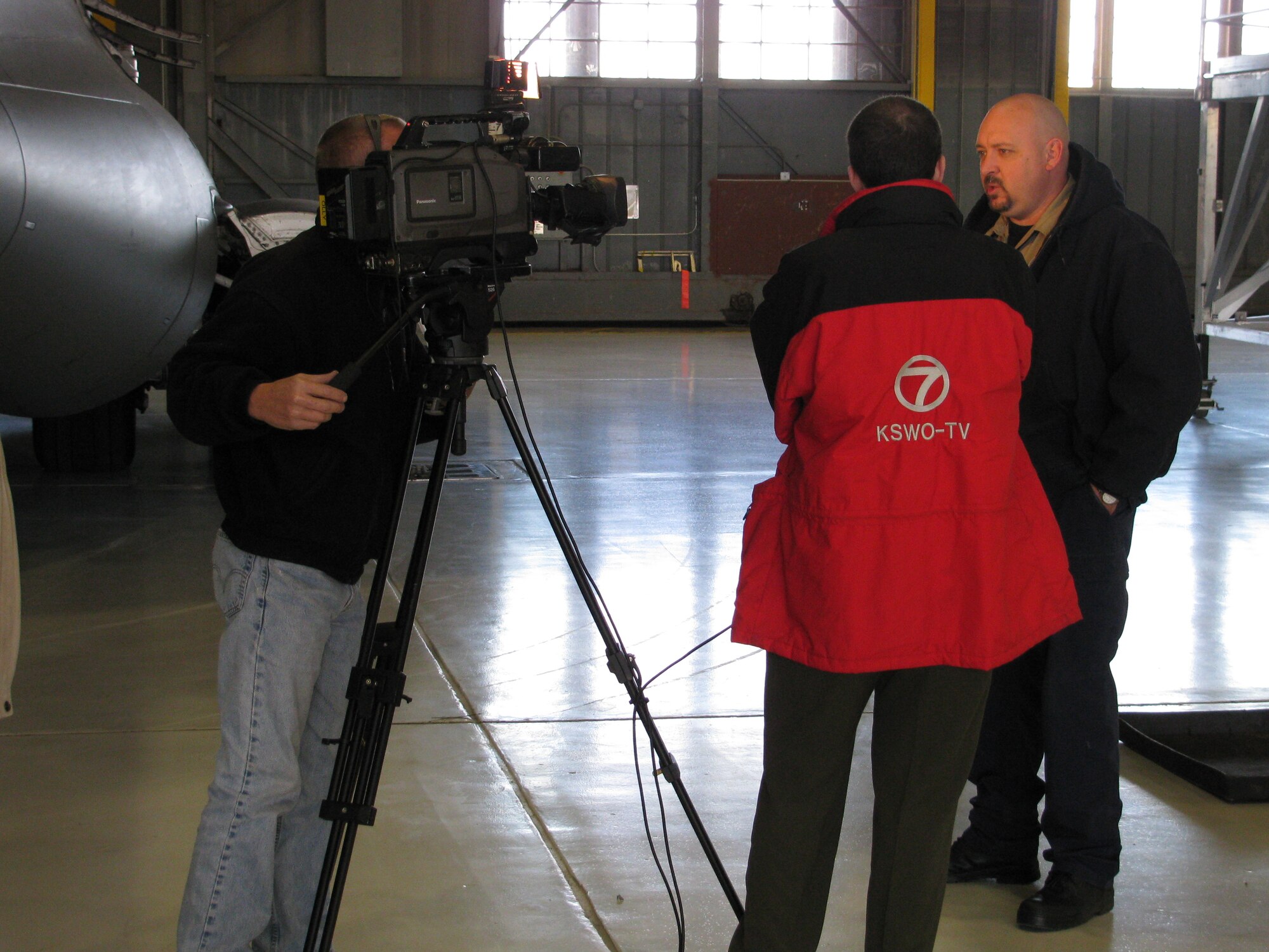Mr. Tony Knott (right) talks to Channel 7 reporters about the C-17 engine maintenance stands Dec. 5 (U.S. Air Force photo/ Mr. David L. Fortuna)