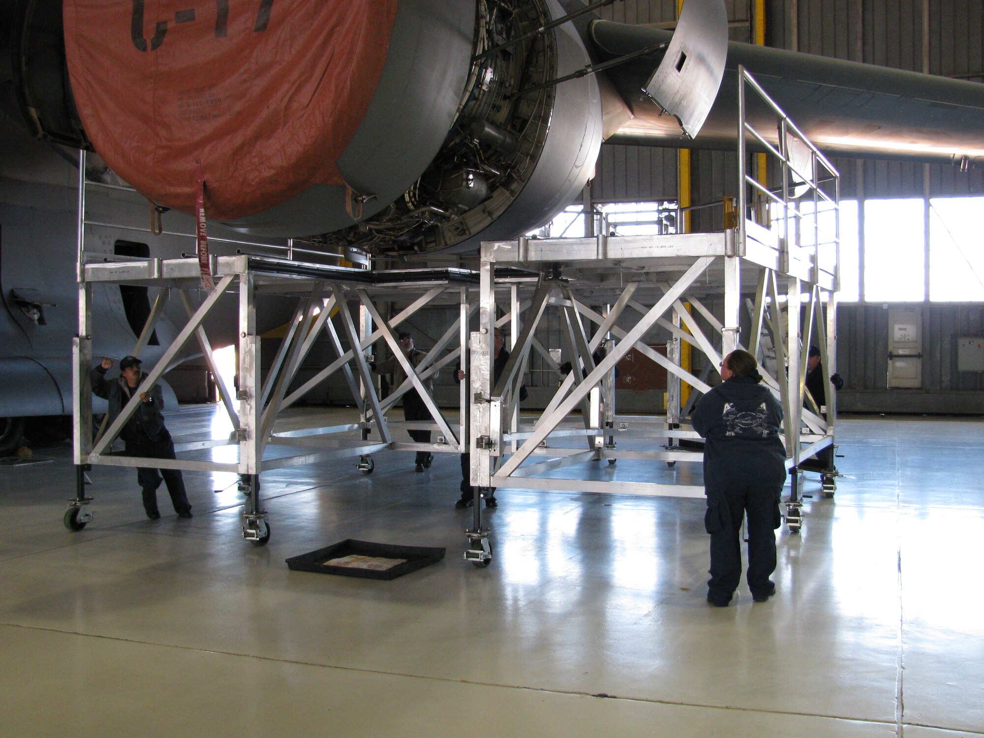 Two 97th Maintenance Directorate mechanics move one of the new C-17 engine maintenance stands into place (U.S. Air Force photo/ Mr. David L. Fortuna)