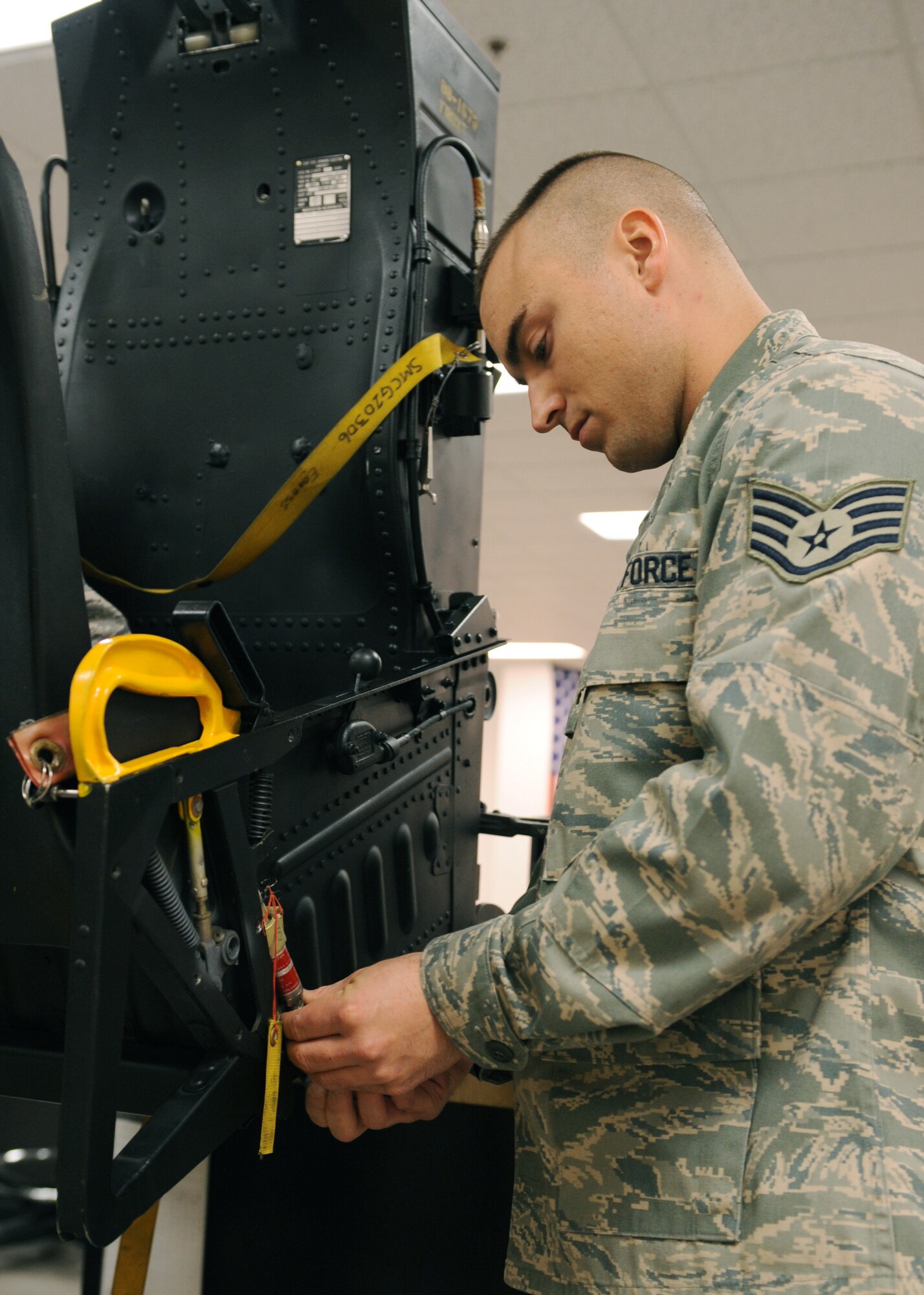 Staff Sgt. Clint Taylor, 4th Component Maintenance Squadron Egress Shop, tightens the gas hose to the ejection initiator on the side of the ejection seat Dec. 4, 2008, on Seymour Johnson Air Force Base, N.C. The egress shop mission is to ensure the safety of the aircrews’ life. (U.S. Air Force photo by Airman 1st Class Whitney S. Stanfield) 
