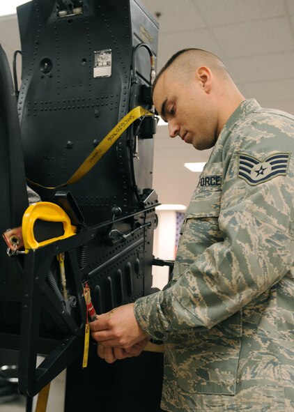 Staff Sgt. Clint Taylor, 4th Component Maintenance Squadron Egress Shop, tightens the gas hose to the ejection initiator on the side of the ejection seat Dec. 4, 2008, on Seymour Johnson Air Force Base, N.C. The egress shop mission is to ensure the safety of the aircrews’ life. (U.S. Air Force photo by Airman 1st Class Whitney S. Stanfield) 

