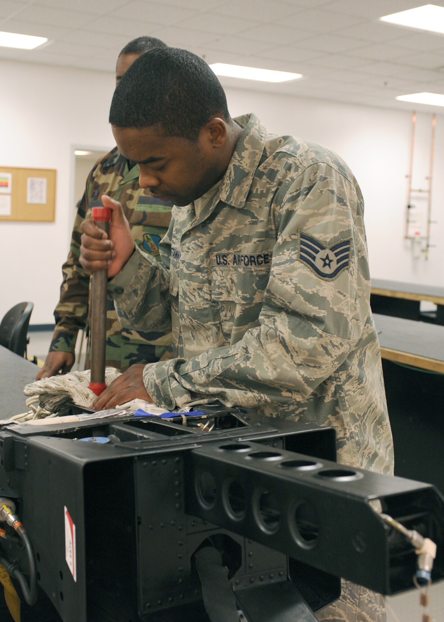 Staff Sgt. Julius Petaway, 4th Operations Support Squadron, packs a drogue parachute in the back of the ejection seat Dec. 4, 2008, on Seymour Johnson Air Force Base, N.C. A drogue parachute comes from the back of the ejection seat to keep the chair upright so it glides through the air more smoothly. (U.S. Air Force photo by Airman 1st Class Whitney S. Stanfield) 
