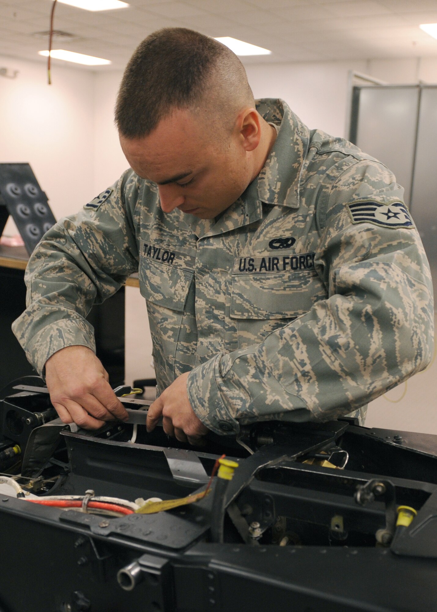 Staff Sgt. Clint Taylor, 4th Component Maintenance Squadron Egress Shop, adds a bearing cover over a wire so it will not get caught in the drogue chute on the pilots chair Dec. 4, 2008, on Seymour Johnson Air Force Base, N.C. The egress shop mission is to ensure the safety of the aircrews’ life. (U.S. Air Force photo by Airman 1st Class Whitney S. Stanfield) 

