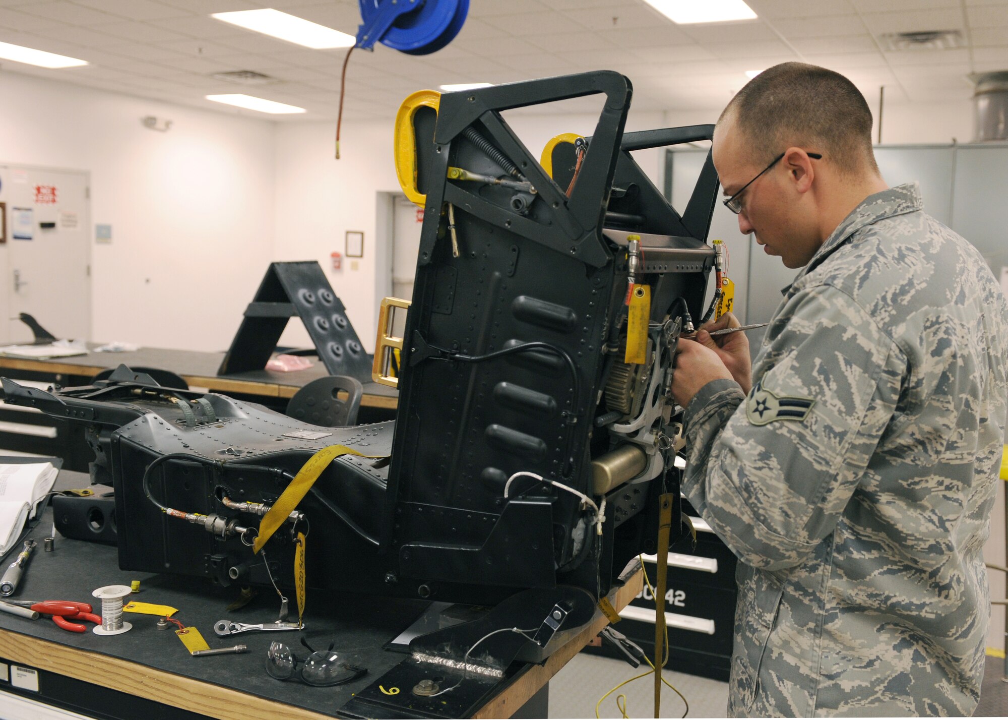 Airman 1st Class Raymond Hernandez, 4th Component Maintenance Squadron Egress Shop, places safety wire around nuts and bolts of the ejection seat to ensure they remain safe Dec. 4, 2008, on Seymour Johnson Air Force Base, N.C. The egress shop mission is to ensure the safety of the aircrews’ life. (U.S. Air Force photo by Airman 1st Class Whitney S. Stanfield) 
