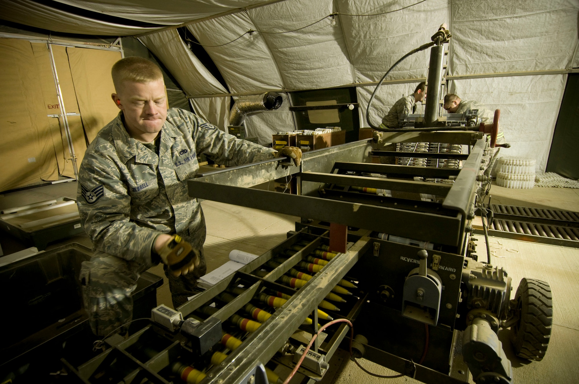 Staff Sgt. James Jerrell inspects 30mm round as they are processed through a GFU-7 "Dragon" at Bagram Air Field, Afghanistan, Dec. 2. He also makes sure that they are re-inserted into their linked tube carriers correctly with no gaps. Sergeant Jerrell is deployed from Moody Air Force Base, Ga., and hails from Ft. Smith, Ark. (U.S. Air Force photo by Staff Sgt. Samuel Morse)(Released)