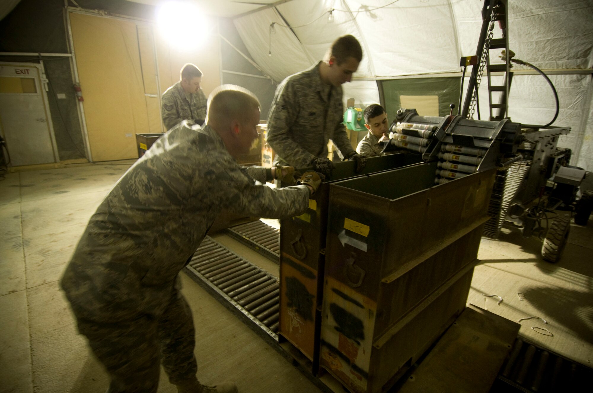 Airmen of the 455th Expeditionary Maintenance Squadron Ammo Flight position an empty container to receive processed rounds from a GFU-7 "Dragon" at Bagram Air Field, Afghanistan, Dec. 2. The team works together to get the job done effectively and ready the 30mm rounds to be uploaded into an A-10 Thunderbolt II. (U.S. Air Force photo by Staff Sgt. Samuel Morse)(Released)