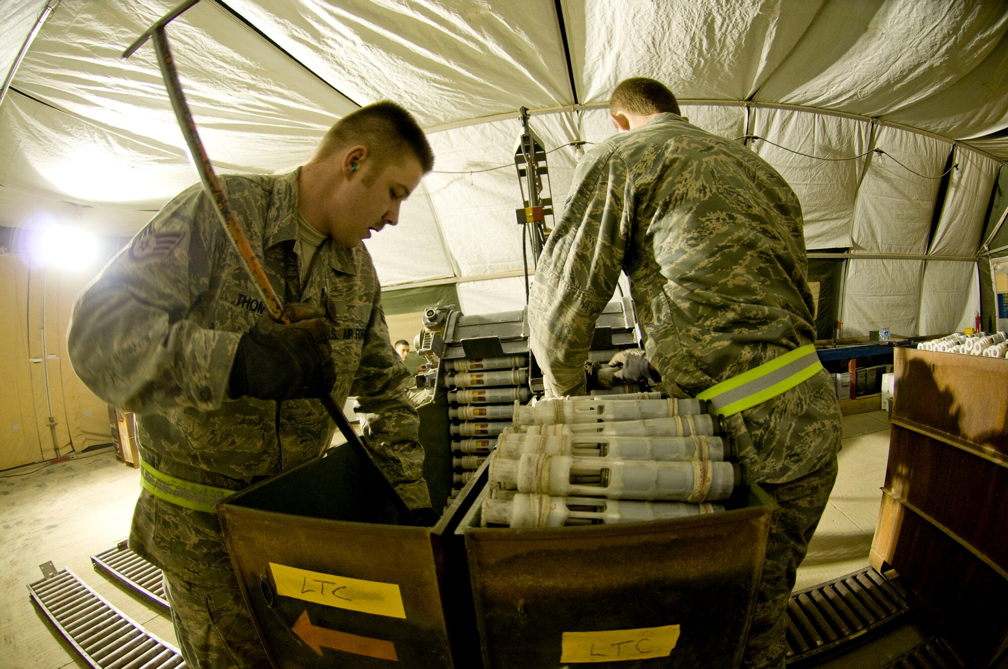 Airman 1st Class Jeb Snow (right) feeds linked tube carriers into a GFU-7 "Dragon" while Staff Sgt. Erik Thomas repacks the processed carriers, containing 30mm rounds at Bagram Air Field, Afghanistan, Dec. 2. The two, part of the 455th Expeditionary Maintenance Squadron Ammo Flight, ensure that the rounds are packed correctly for easy uploading into the A-10 Thunderbolt II. Both are deployed from Mountain Home Air Force Base, Idaho. Airman Snow is from Wasilla, Alaska, and Sergeant Thomas is from Bennington, Vt. (U.S. Air Force photo by Staff Sgt. Samuel Morse)(Released)