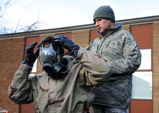 Airman 1st Class David Rodriguez from the 100th Civil Engineering Squadron assists Senior Airman Christopher Bourand from the 100th Communications Squadron with his gas mask while suiting up in MOPP 4 (Mission Oriented Protective Posture) during the “Ability To Survive and Operate” (ATSO) Rodeo Dec. 5, 2008, at RAF Mildenhall, England. (U.S. Air Force photo by Staff Sgt. Jerry Fleshman)