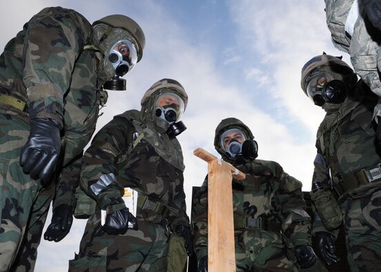 Airmen huddle together to learn how to read M9 detection tape for contamination and to take the proper procedures on how to correctly set up a controlled area during the “Ability To Survive and Operate” (ATSO) Rodeo at the Main Fitness Center Dec. 5, 2008, in RAF Mildenhall, England. The purpose of the training was to prepare Airman in participating in an upcoming Phase 1 and 2 exercise Dec. 8th-12th. Training consisted of hands-on self aid buddy care, unexploded ordnance identification and procedures, pre- and post-attack actions, and operating a contamination control area. (U.S. Air Force photo by Staff Sgt. Jerry Fleshman)