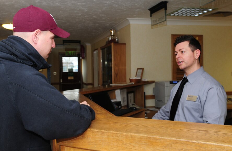 Paolo Sciascia, 100th Force Support Squadron Gateway Inn guest services representative, chats with customer Senior Airman John McKnight, 352nd Maintenance Squadron, who is new to RAF Mildenhall, Nov. 21. The front desk is manned 24-hours-a-day, 365-days-a-year. Active duty military, Department of Defense civilians and retirees are authorized to stay in any of the Air Force Inns worldwide. Official travelers and guests PCSing to and from RAF Mildenhall are considered priority one guests. Space-available bookings are priority two, according to Christian Peal, Gateway Inn manager, and guests may make their reservations up to 30 days in advance, depending on occupancy. All reservations are on a first-come, first-served based, regardless of rank. (U.S. Air Force photo by Karen Abeyasekere)