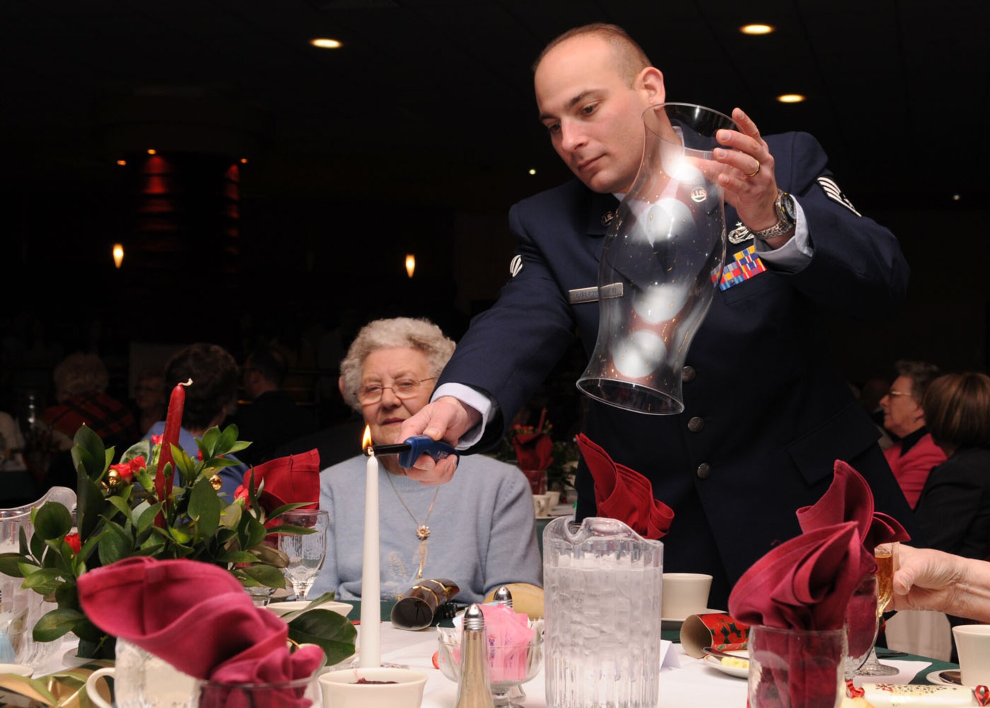 Staff Sgt. Jamie Giekzewski from the 100th Force Support Squadron, lights a candle for the guests during the 27th annual Senior Citizens Luncheon Dec. 3, 2008, in RAF Mildenhall, England. The event is held to give senior citizens in the local area an opportunity to have lunch, play games, and a chance to meet new people. (U.S. Air Force photo by Staff Sgt. Jerry Fleshman)