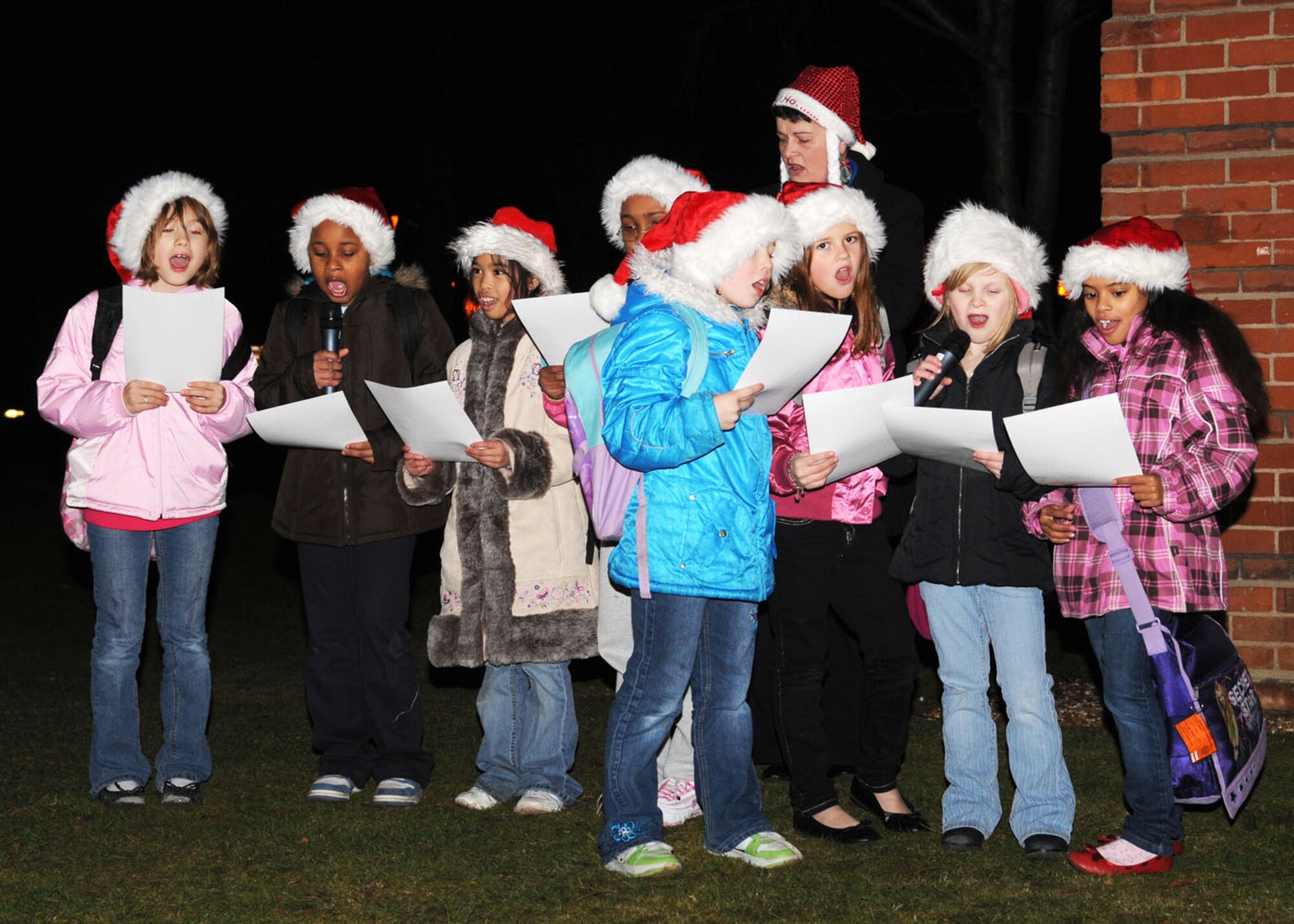 Children from RAF Mildenhall’s Youth Center provided Christmas carols to the crowd during the Christmas tree lighting ceremony Dec. 4, 2008, in RAF Mildenhall, England. Team Mildenhall’s Christmas tree can be found near Building 422 across Mickey’s Tea Bar. (U.S. Air Force photo by Staff Sgt. Jerry Fleshman)
