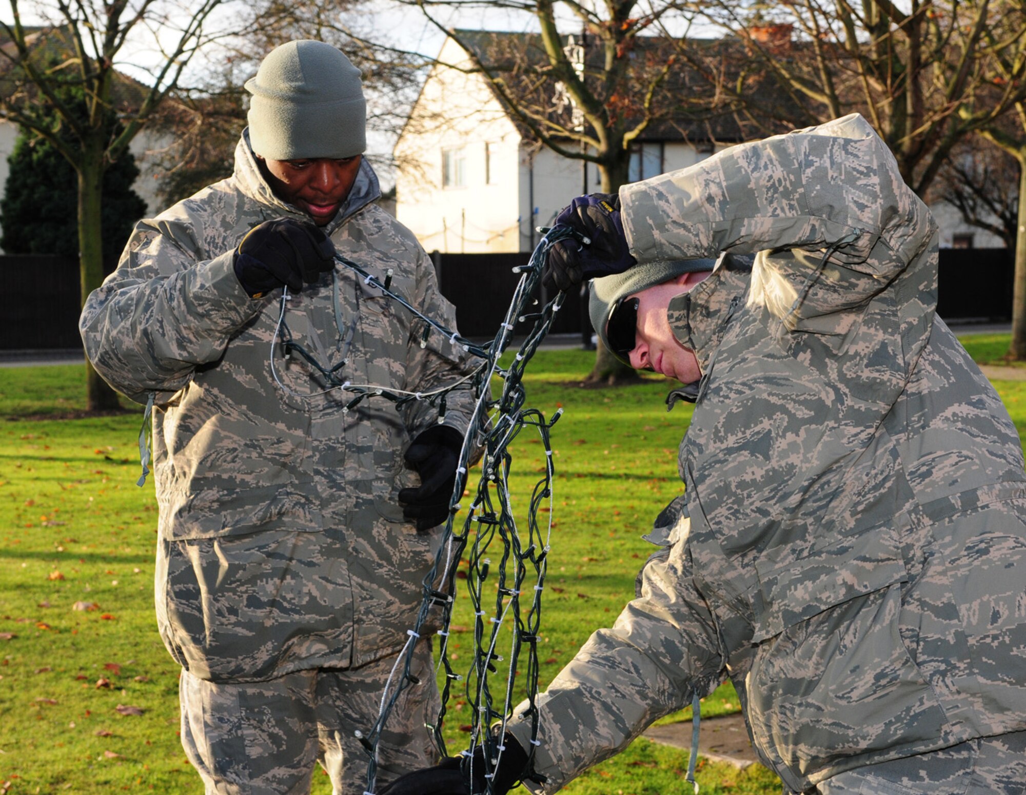 Staff Sgt. Derrick Mitchell, left, 100th Civil Engineer Squadron, and Tech. Sgt. David Stollings, also 100th CES, unravel Christmas lights ready to be put on the holiday tree Dec. 2. (U.S. Air Force photo by Karen Abeyasekere)