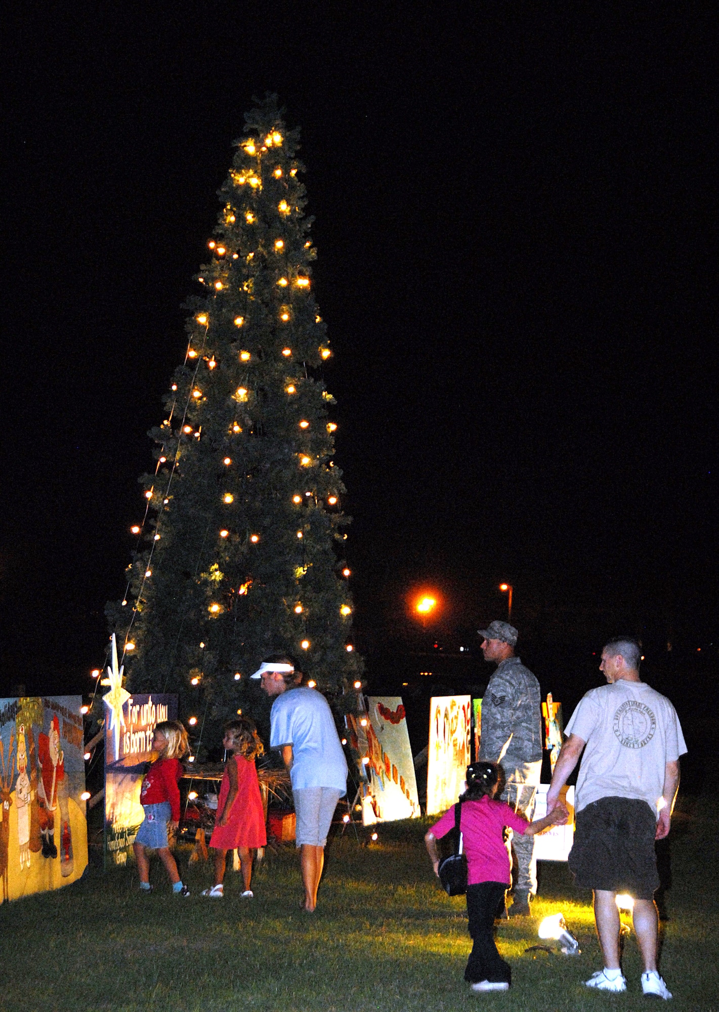 ANDERSEN AIR FORCE BASE, Guam -- Team Andersen members look at the newly lit base Christmas tree at Arc Light Park Dec. 4. Both McGruff the Crime Dog and Santa were in attendance at the ceremony. (U.S. Air Force photo by Ralph Ridgeway)