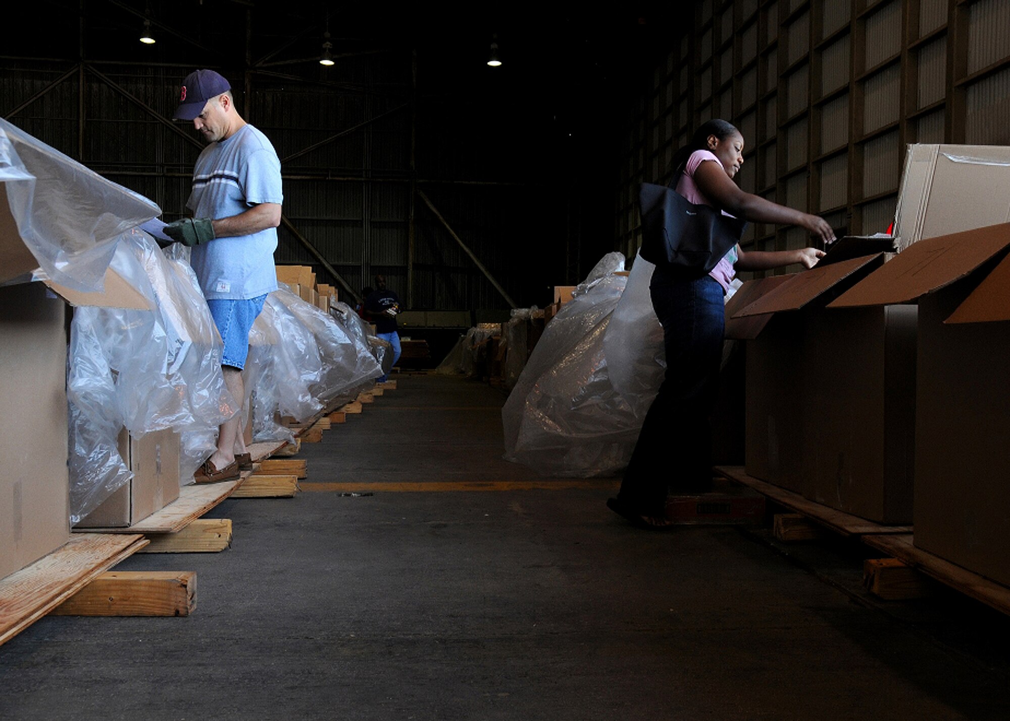 ANDERSEN AIR FORCE BASE, Guam - Chief Master Sgt. James Cornell (left), 36th Maintenance Group Superintendent and Staff Sgt. Lishey Brown, 36th Force Support Squadron, Retirements and Separations pack boxes for Operation Christmas Drop 2008 here at Hangar 4. This the organization has received ten of thousands of donations and over $30,500 in sponsorships.(U.S. Air Force photo by Senior Airman Nichelle Griffiths)