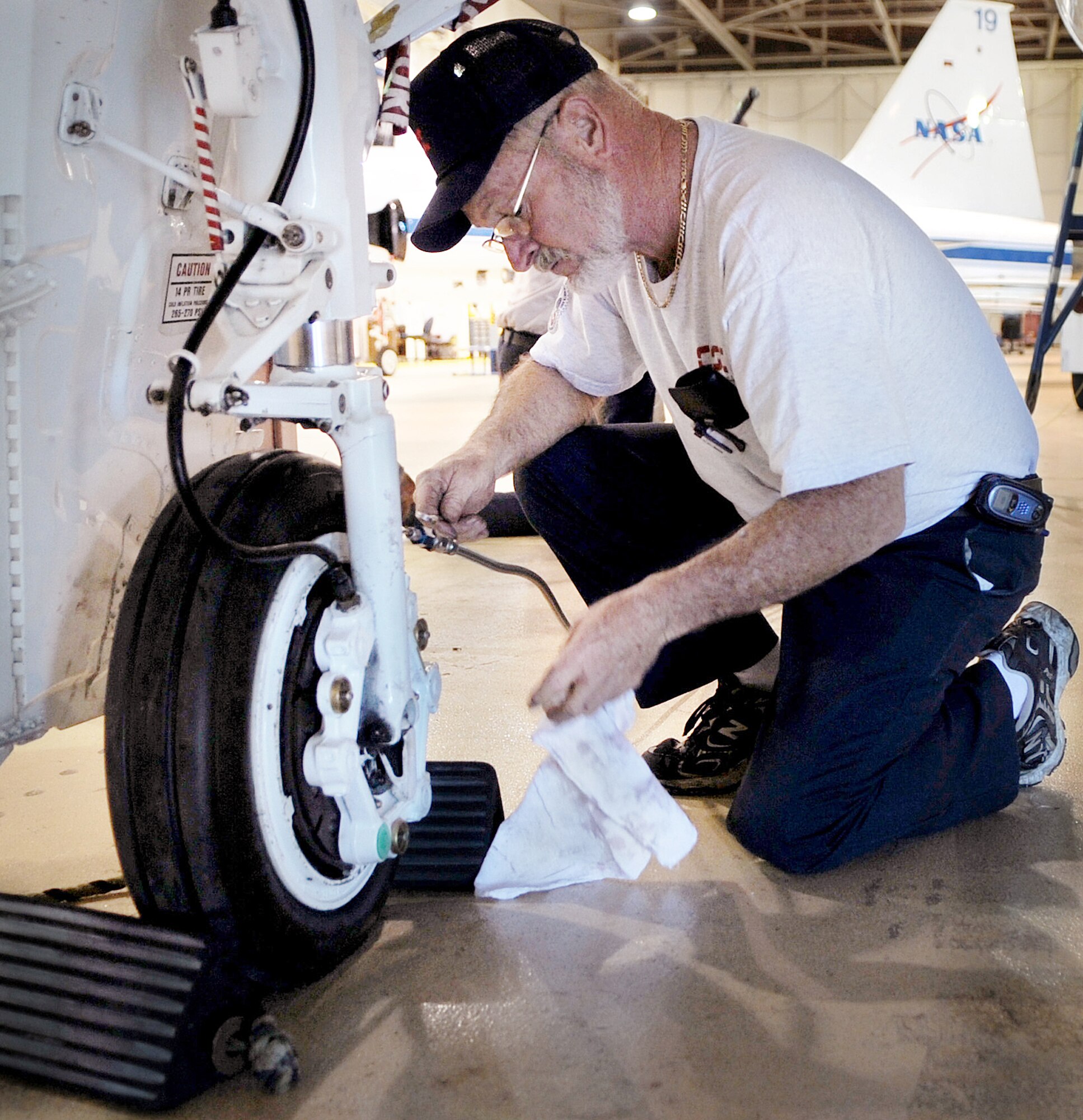 Mike Parrott performs a routine brake check on a NASA T-38 Dec. 2 in Ellington Field, Texas. Mr. Parrott is an unscheduled maintenance crew leader for NASA. (U.S. Air Force photo/Staff Sgt. Desiree N. Palacios) 
